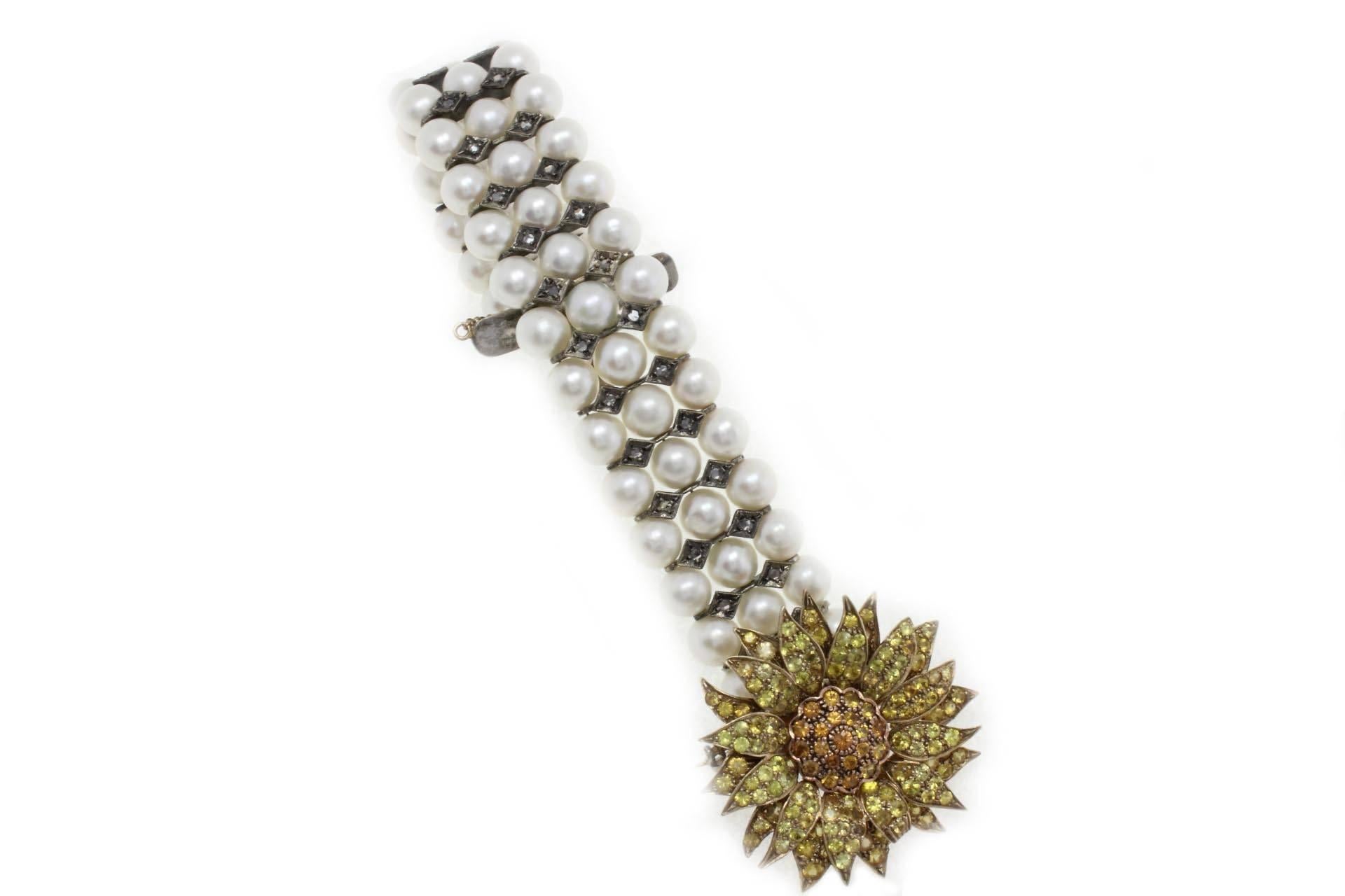 Pearls bracelet with sunflower shaped clasp in 9 kt yellow gold and silver mounted with natural rose cut diamonds and sapphires.
Pearls (40.50 gr) 
diamonds (0.62 kt) 
sapphires (6.71 kt)
tot. weight 79.20
r.f  griu

For any enquires, please contact