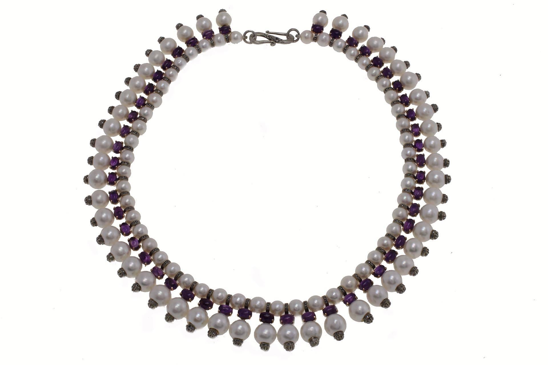 Sophisticated pearls necklace in 9 kt gold and silver embellished with diamonds and amethysts.

pearls (71.40 gr)
diamonds (1.19 kt) 
amethysts (23.53 kt).
tot.weight 106.10 gr
r.f urer