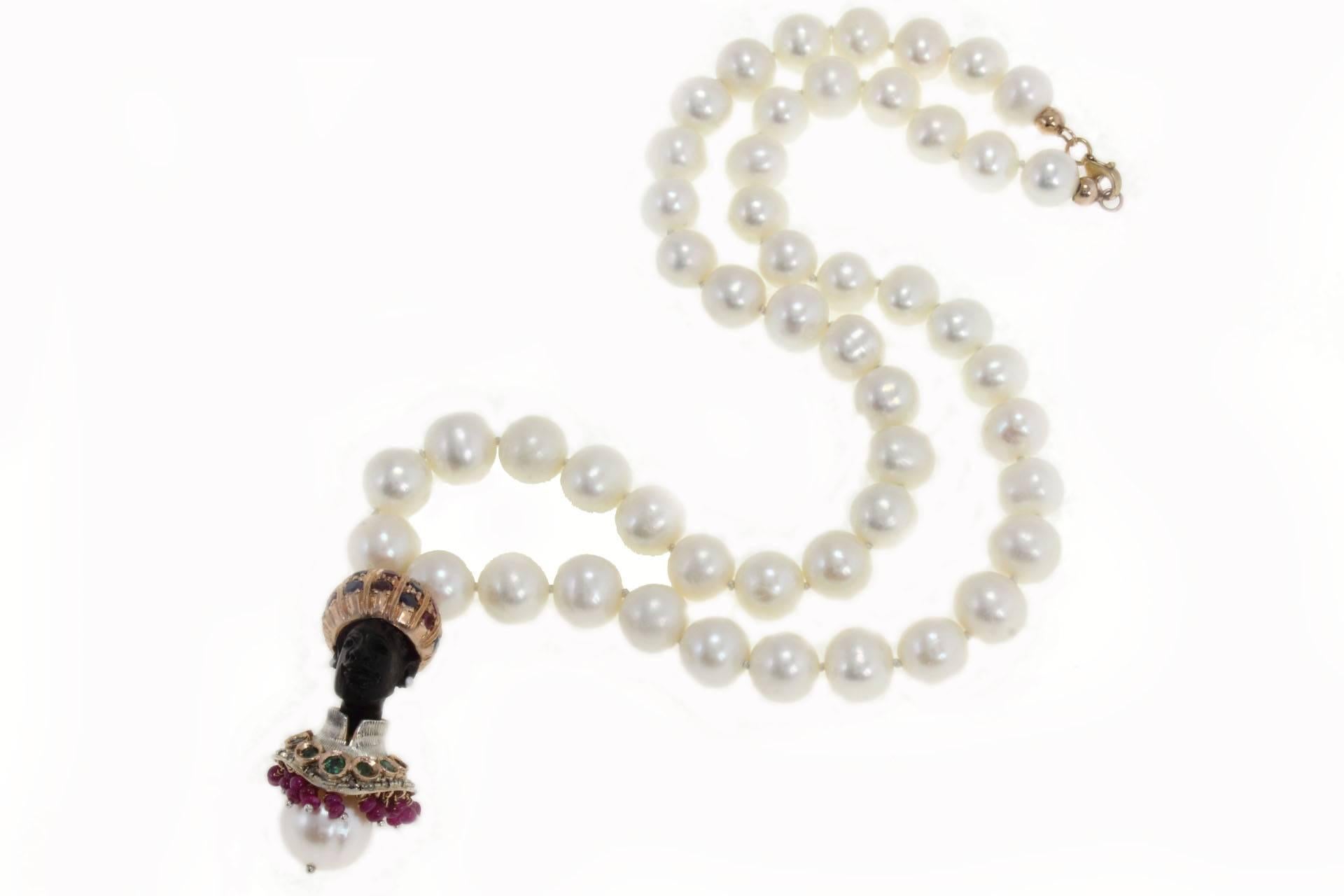 Necklace in 9kt gold composed by a beaded necklace linked with depicting Venetian Moretti Pendant exhibit a meticulous craftsmanship. Moretti pendant is composed of, silver, diamonds, rubies, blue sapphires a pearl and ebony. Instead the necklace is