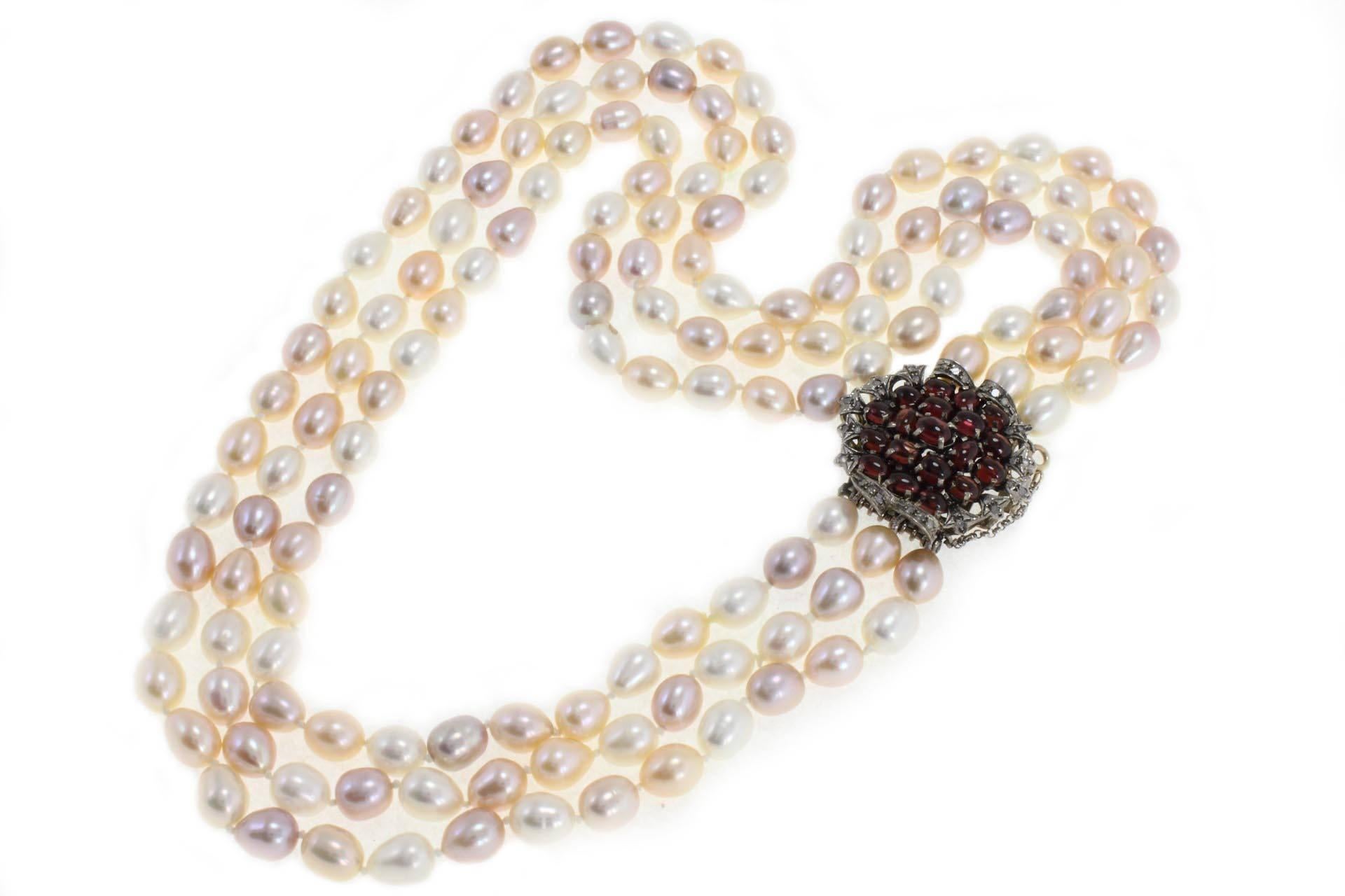 Amazing necklace in 9kt gold composed of multicolor pearls and a silver clasp mounted with diamonds and garnets. 

diamonds (0.35 kt) 
garnets (14.83 kt)
 pearls (149.40 gr) (8/9 mm)
tot.weight 170.40
r.f  gucr