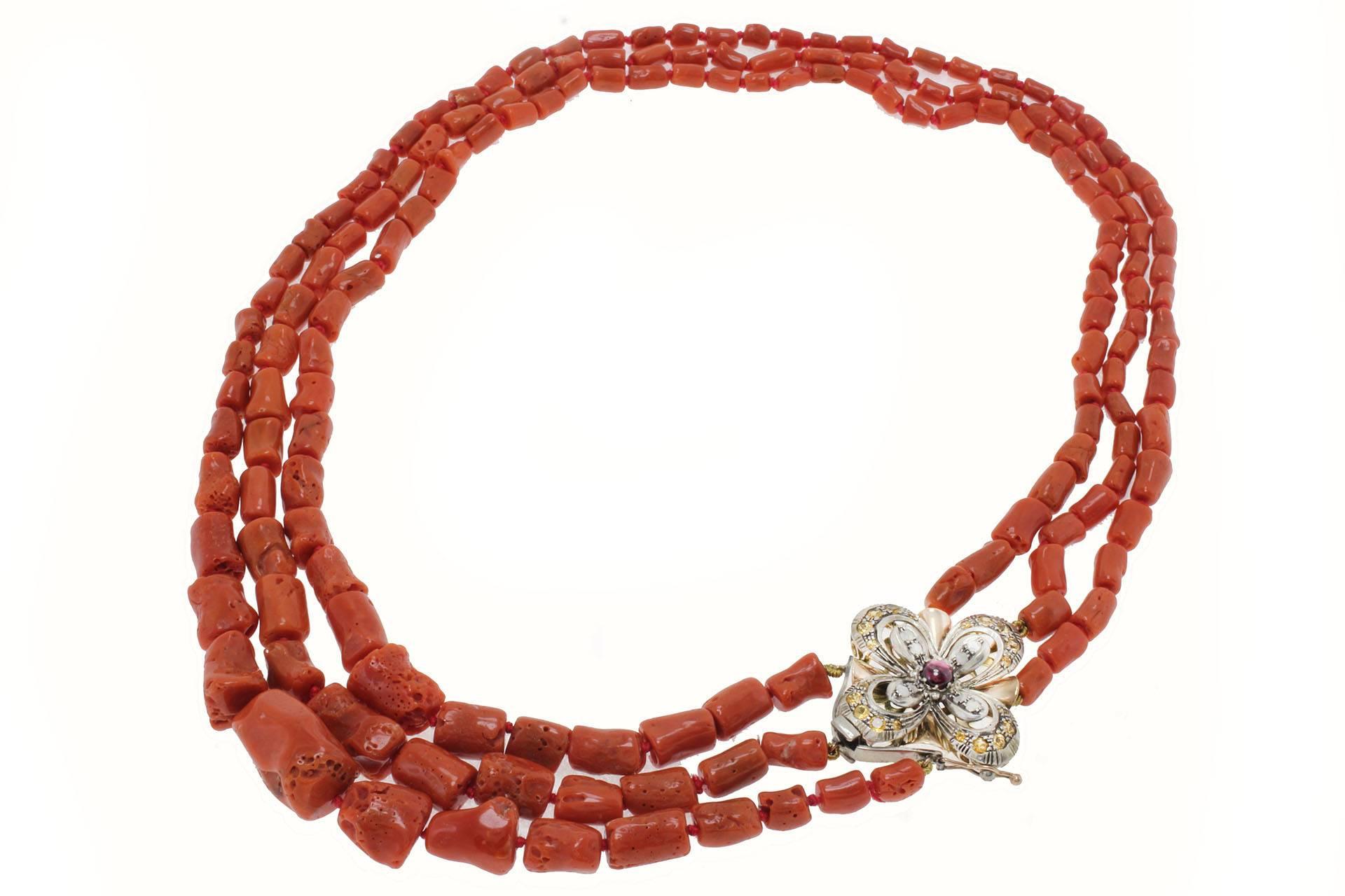 Coral necklace composed of 3 coral rows and one gold and silver flower haped clasp mounted with diamonds, topaz and garnet.

Coral (129.00 gr) 
diamonds (0.52 kt) 
topaz and garnet (3.14 kt)
tot.weight 145.90
r.f  ufoi