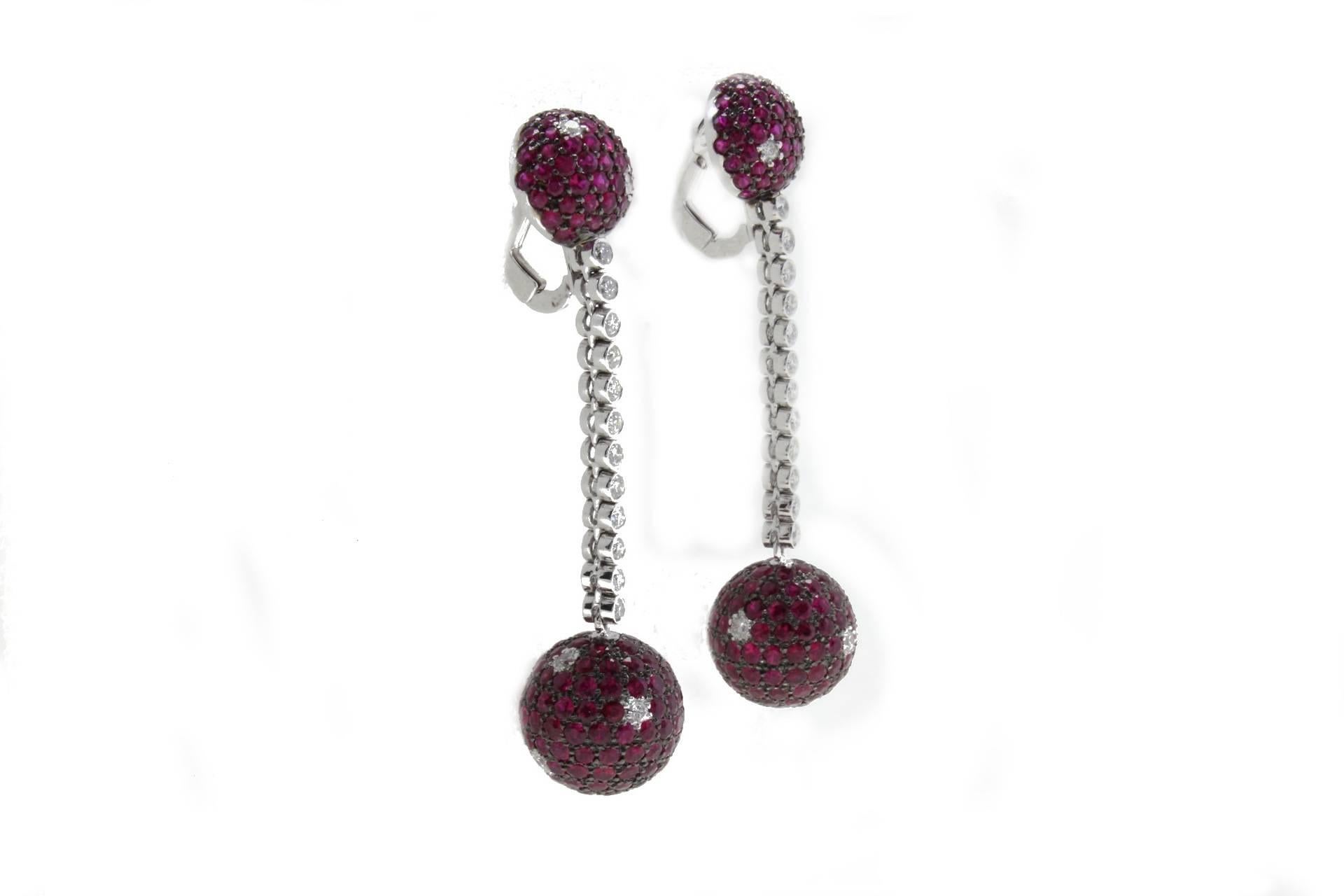 Dangle earrings18kt white gold mounted with diamonds lines that link two balls covered in rubies and diamonds.

Diamonds 1.24 kt
Rubies 11.41 kt
Tot.Weight 14.70 gr
R.F icoh