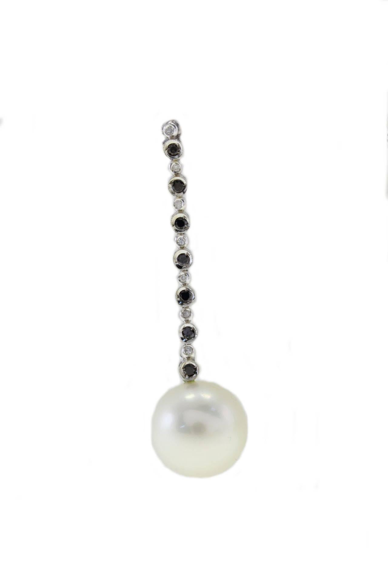Dangle earrings in 14Kt white gold with a chain of black and white diamonds  that links them to one pearl each with a diameter of 11/12mm.
Delightful pairs of earrings that you will not resist to wear in any occasion.

black and white diamonds