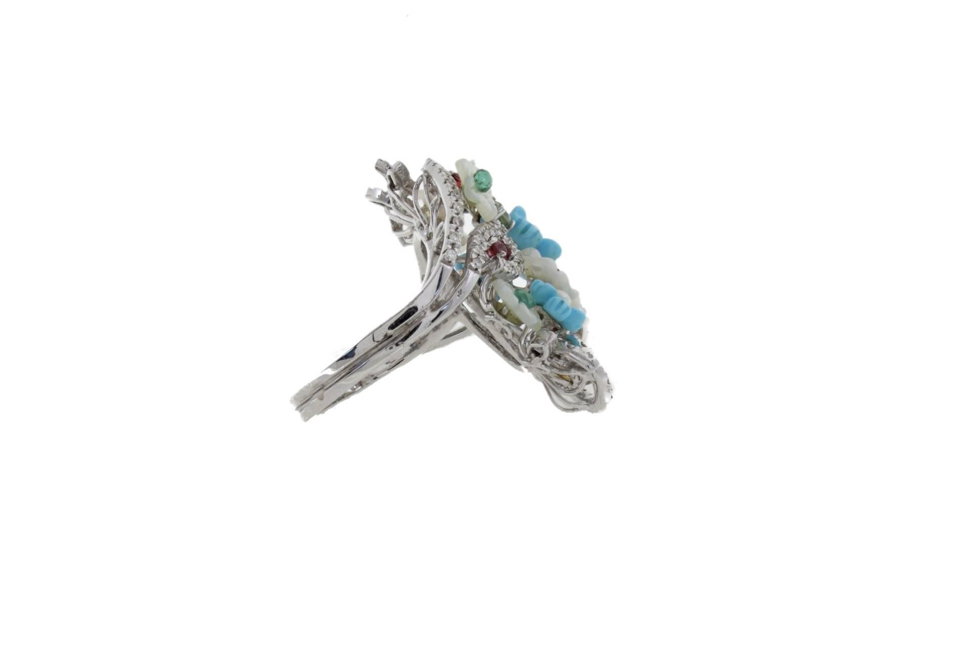 Cocktail ring in 14k white gold composed of flower shaped mother-of-pearls, flower shaped turquoises, pearls, emeralds, rubies and yellow sapphire all around.

Diamonds 0.69 kt
Emeralds, Rubies, Sapphire 0.97 kt
Pearls 0.10 gr
Turquoise,