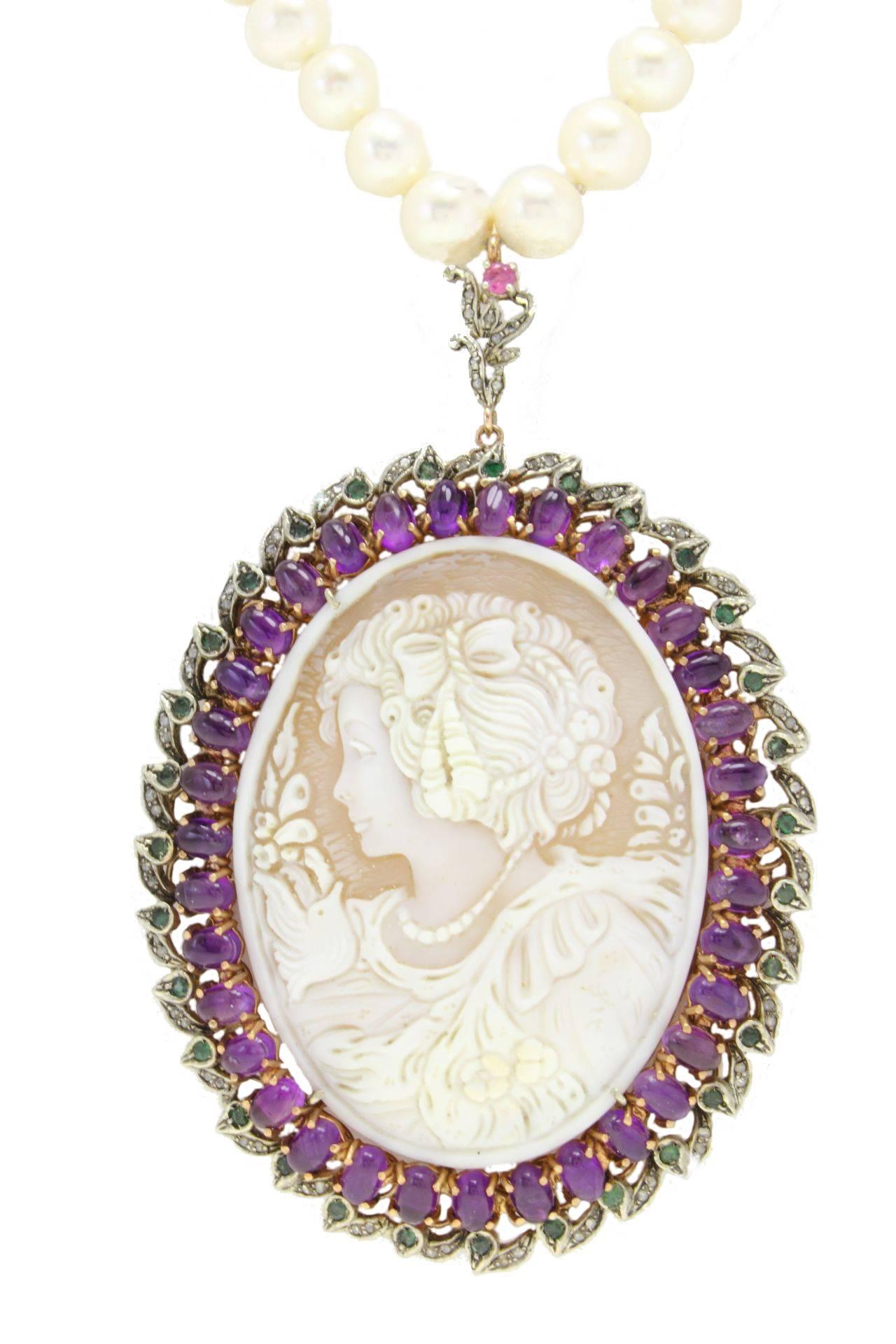  Mounted on 9Kt gold and silver, this charming cameo is surrounded of a frame of amethyst (18.51Kt), emeralds and ruby(1.79Kt), and diamonds on the edges(0.64Kt).And it is a pendant of a single strand of pearls with a diameter 8-9mm(47.6gr). tot