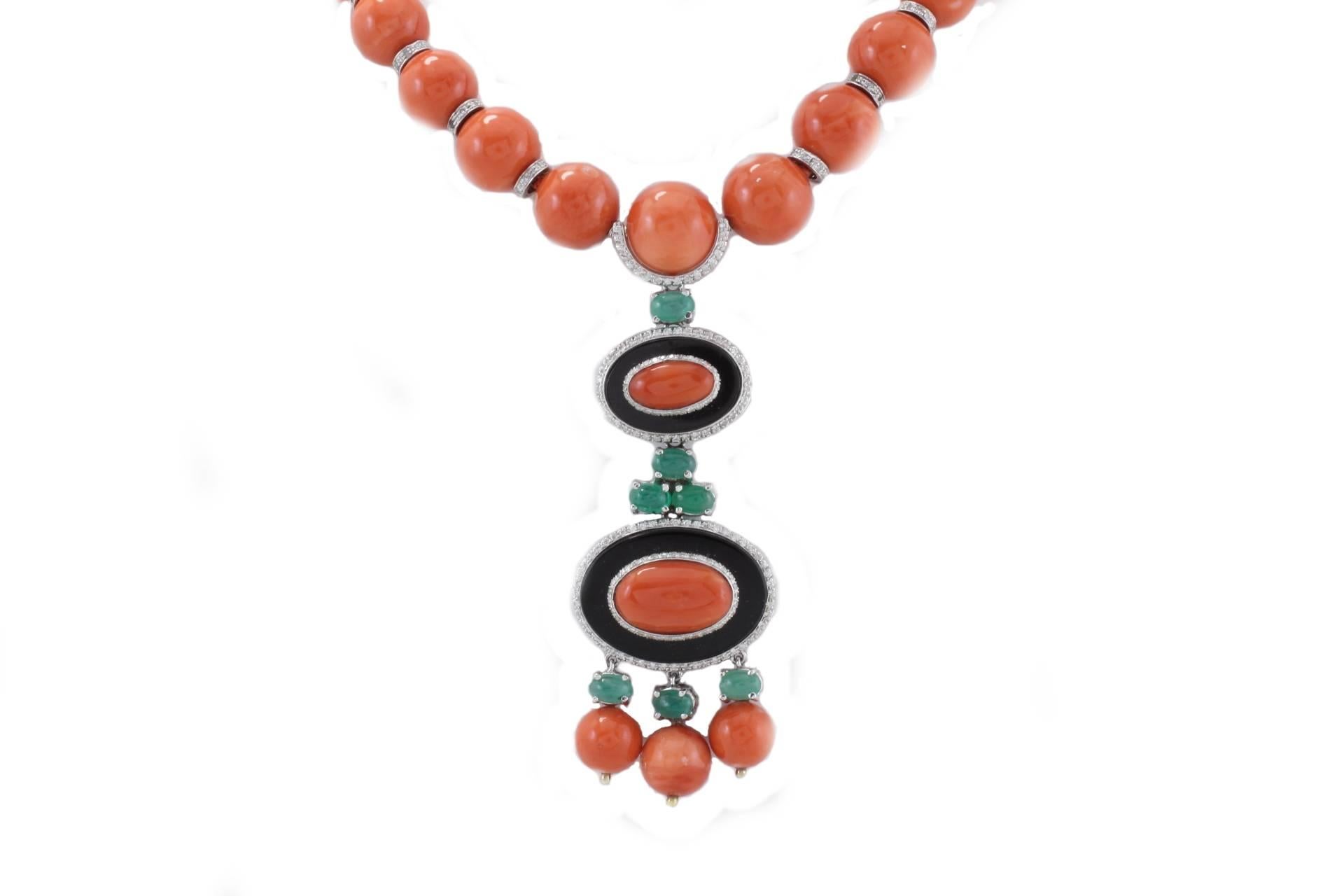 Charming necklace composed of a single  coral(66.5gr) strand spheres  linked with diamonds circle among them (2.42Kt), as pendant onyx (2.9gr) circle shaped  with coral details on the top of them and emeralds(3.08Kt) which links them. All is mounted