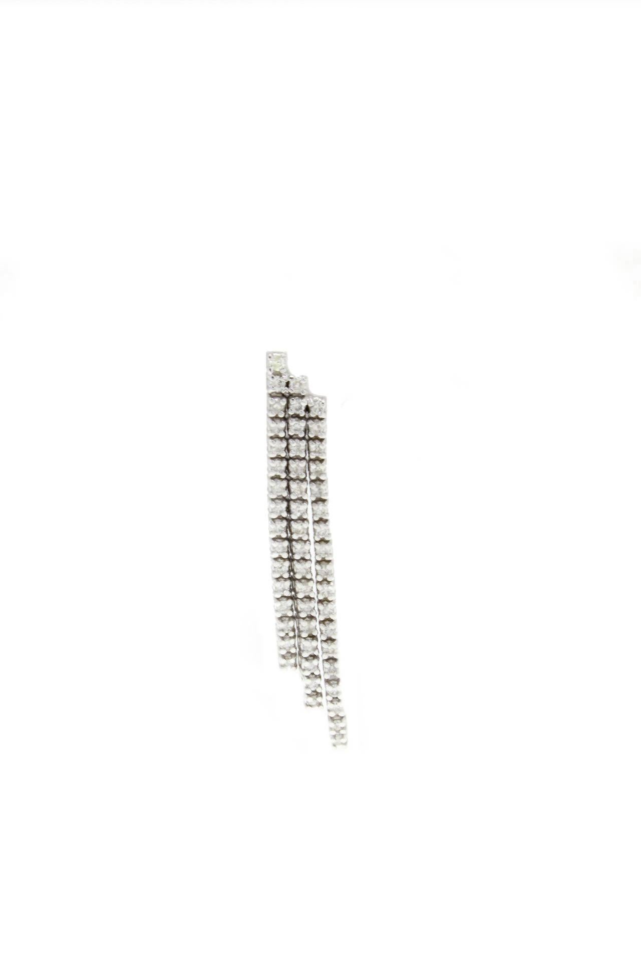  These lustrous earrings are simply composed of 3 stripes of diamonds, like a diamonds waterfall (1.20Kt), mounted on 14Kt white gold. 
Tot weight 5.7 gr  both earrings, single one 2.85 gr

R.f. 822501