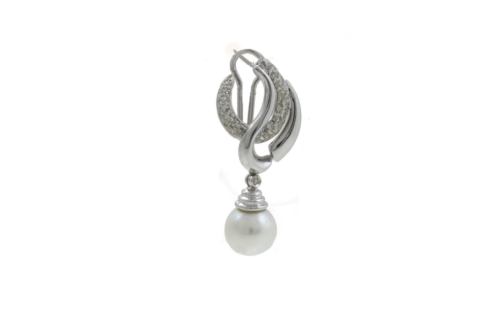 Dangle earrings in 18Kt white gold with a design that's alternating one side of diamonds and one side of white gold. On the bottom there are two pearls that's complete them. 

Diamonds 1.22 Kt
Pearls 29.62 gr diameter 12/13mm
Tot weight 22.7 gr

Rf.