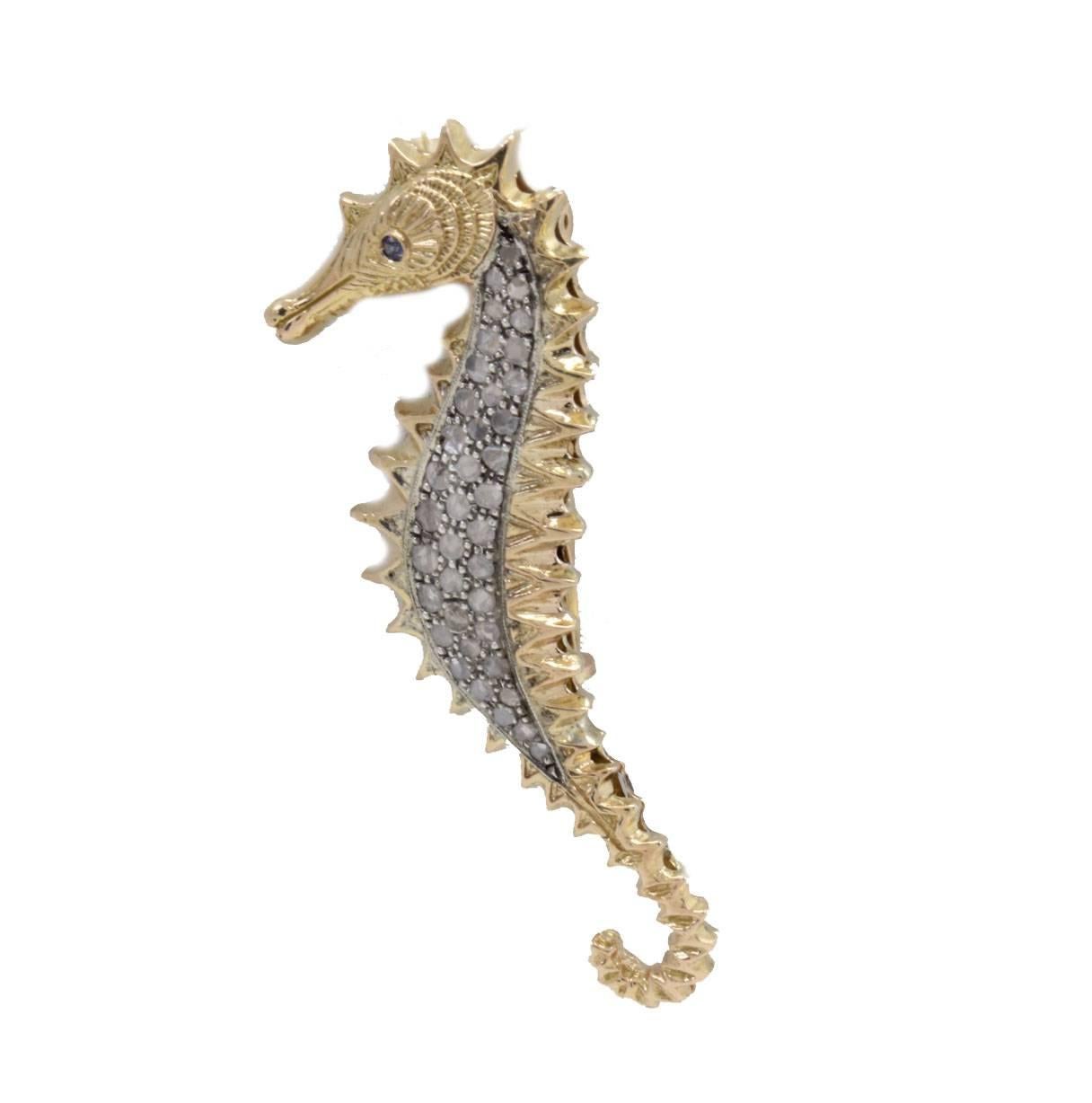 Graceful  brooch and pendant sea horse shaped created in 14Kt yellow gold and silver, embellished of diamonds and as eye a little blue sapphire.

Diamonds 1.07 Kt
Blue sapphire 0.04 Kt
Tot weight 12.1 gr
Rf. gihc 