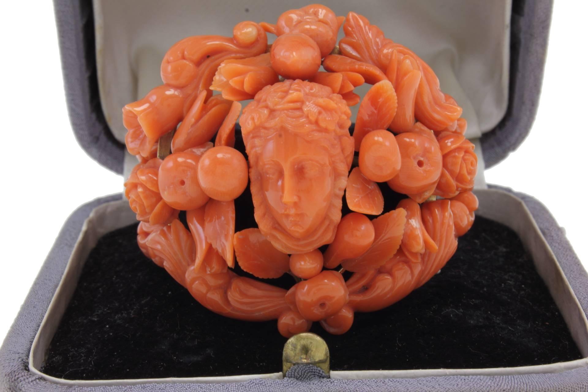 SHIPPING POLICY: 
No additional costs will be added to this order. 
Shipping costs will be totally covered by the seller (customs duties included).

Elegant engraved coral  and gold bracelet. In the center a carved face surrounded by carved flowers,