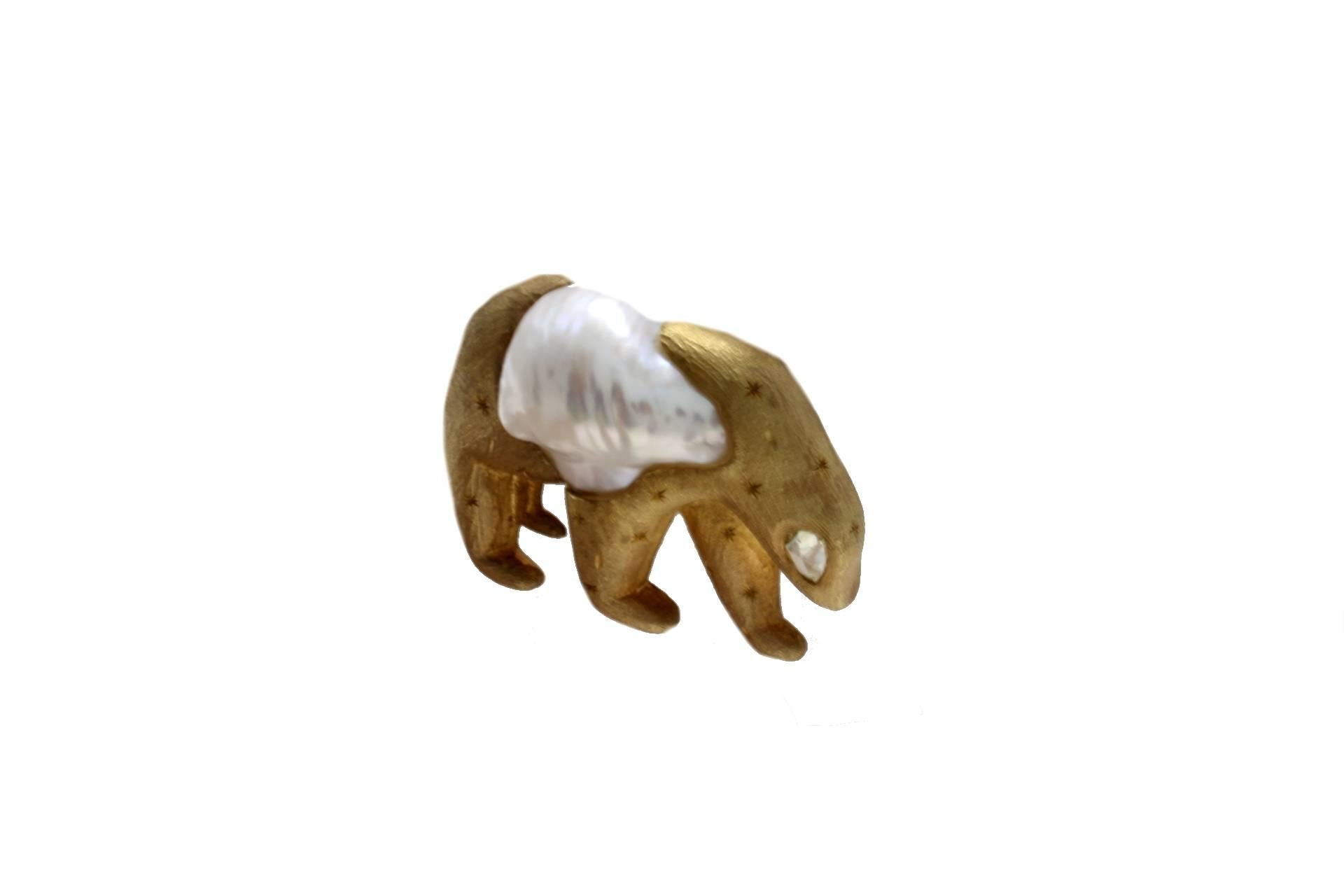 Animal shaped brooch in 9kt yellow gold composed of a mother of pearl body and a diamond eye.

diamond 0.30kt
pearl 6.60gr
tot weight 24.0gr
r.f.  uuoh