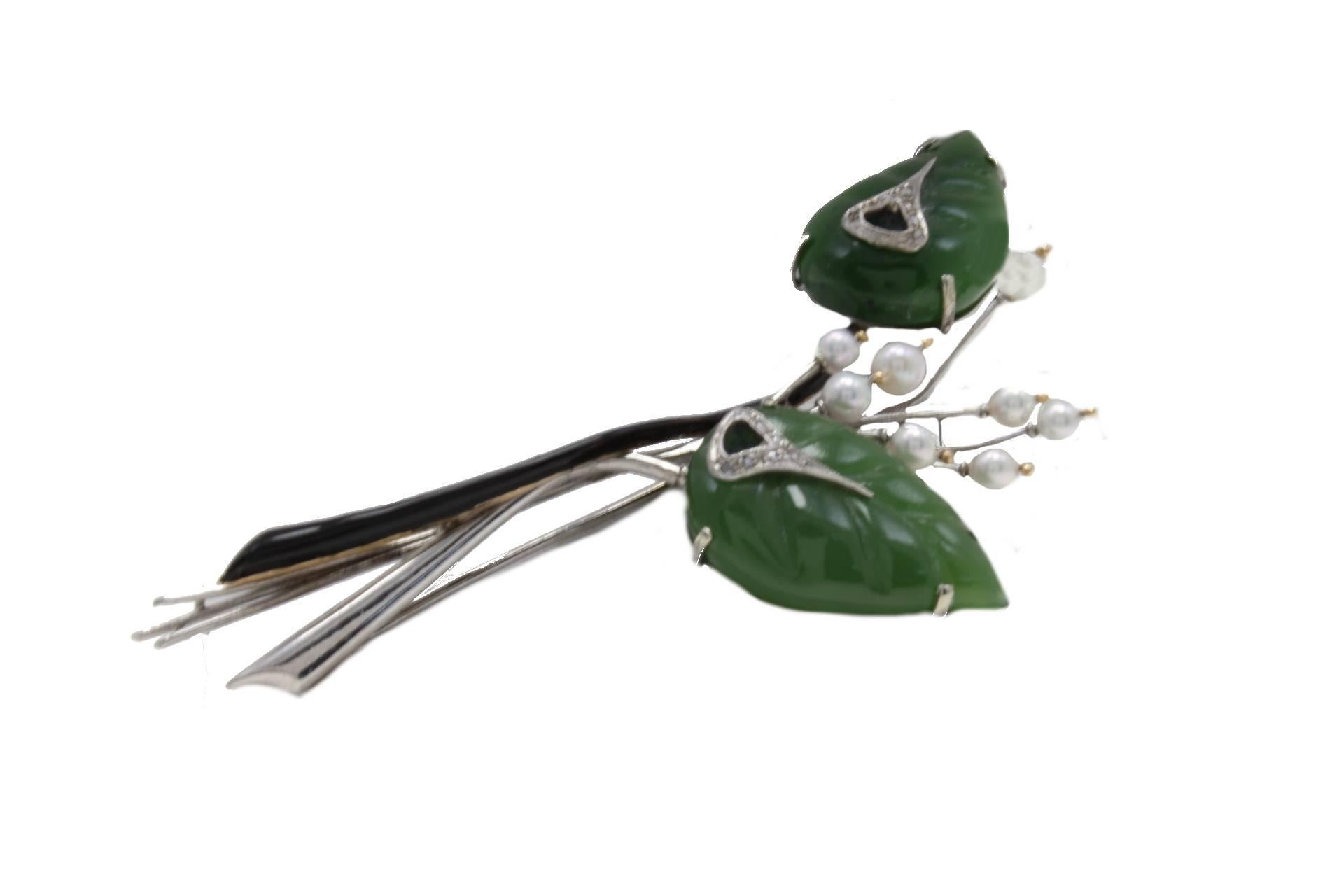 Retro brooch in 14kt yellow and white gold composed of two leaves shaped jade  with diamonds and eight stems with a pearl on the top and one onyx stem.

diamonds 0.13kt
tot weight 22.7gr
r.f.  giio