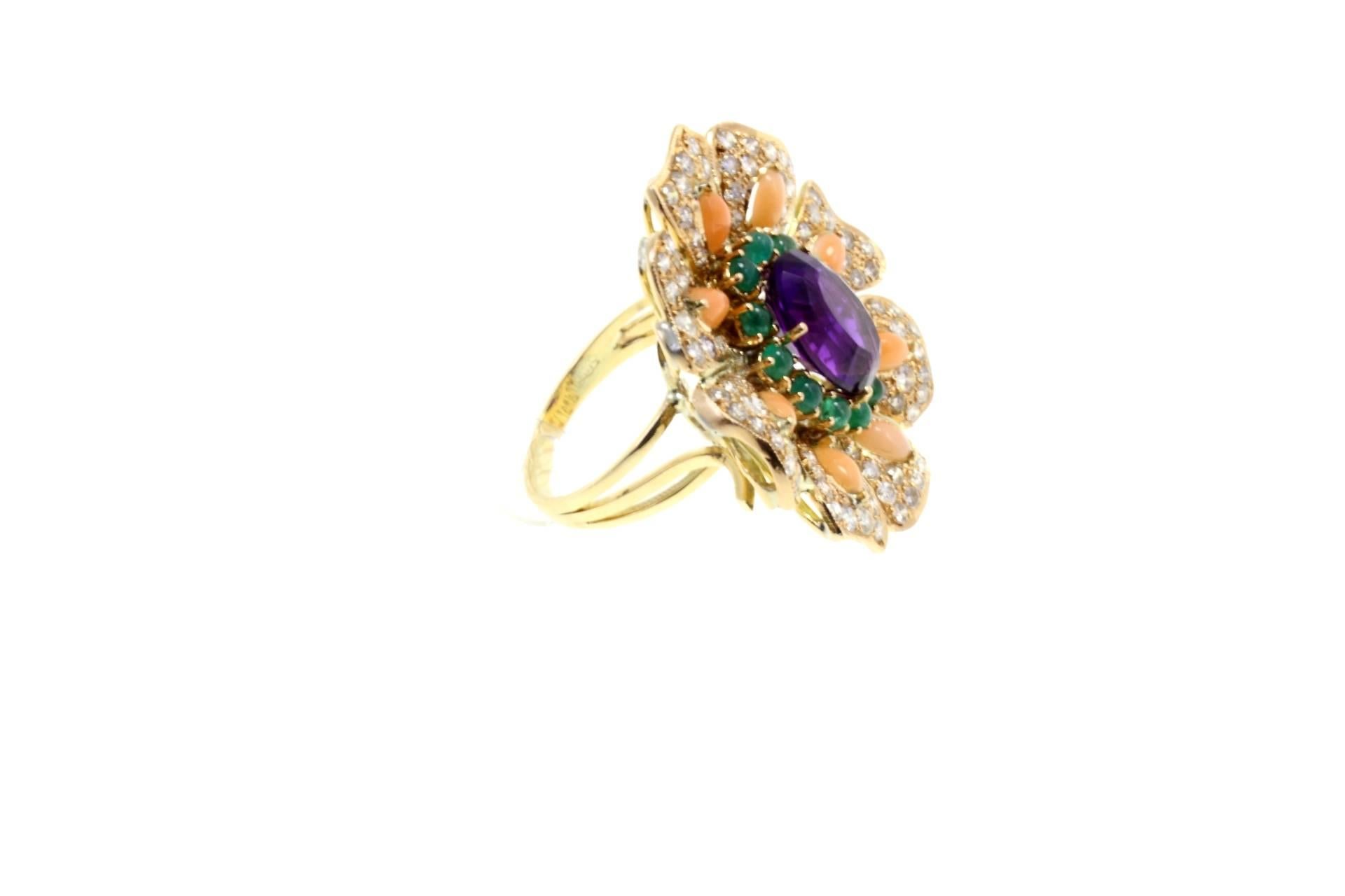 Shiny cocktail ring in 14kt yellow gold composed of a central amethyst surrounded by a crown of emeralds and by petals covered in diamonds, embellished with pink coral.

diamonds 2.85kt
emeralds1.28kt
tot weight 15.8gr
r.f.  hrgo