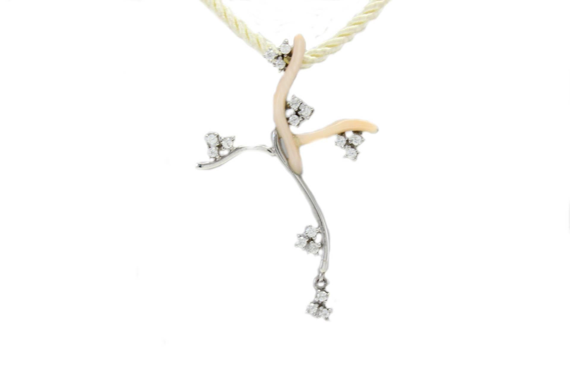 Stylizated cross shaped pendant in 18kt white gold and pink coral embellished with diamonds.

diamonds 0.30kt
tot weight 3.5gr
r.f. raa