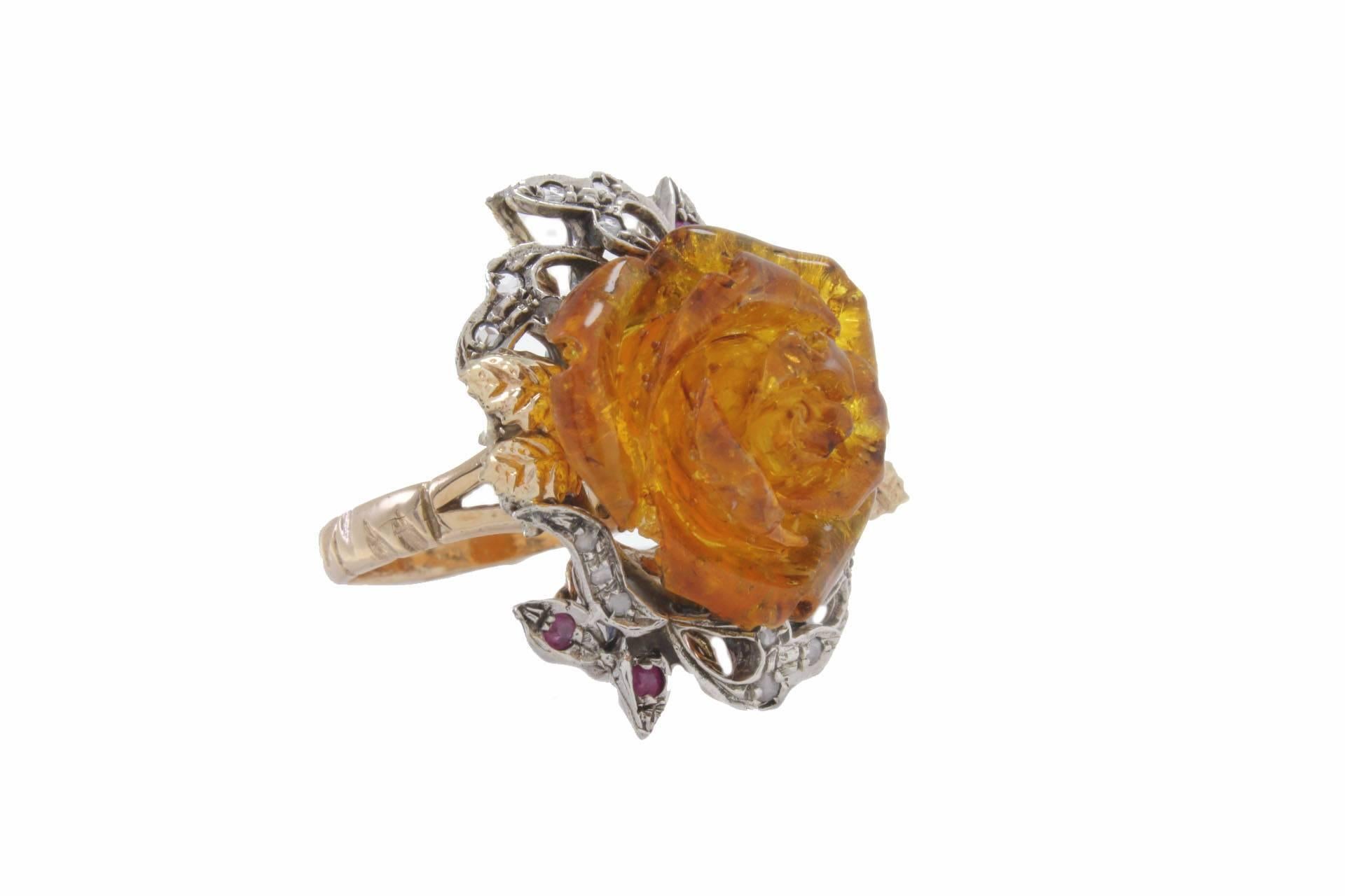 

 This is a classic ring is mounted in 9Kt gold and silver details, little leaves are surrounding the resin amber rose shaped, the leaves are  adorned alternate with diamonds and rubies.
Ring Size: ITA 16 - French 56 - US 7.5 - UK P
Tot weight 8.6