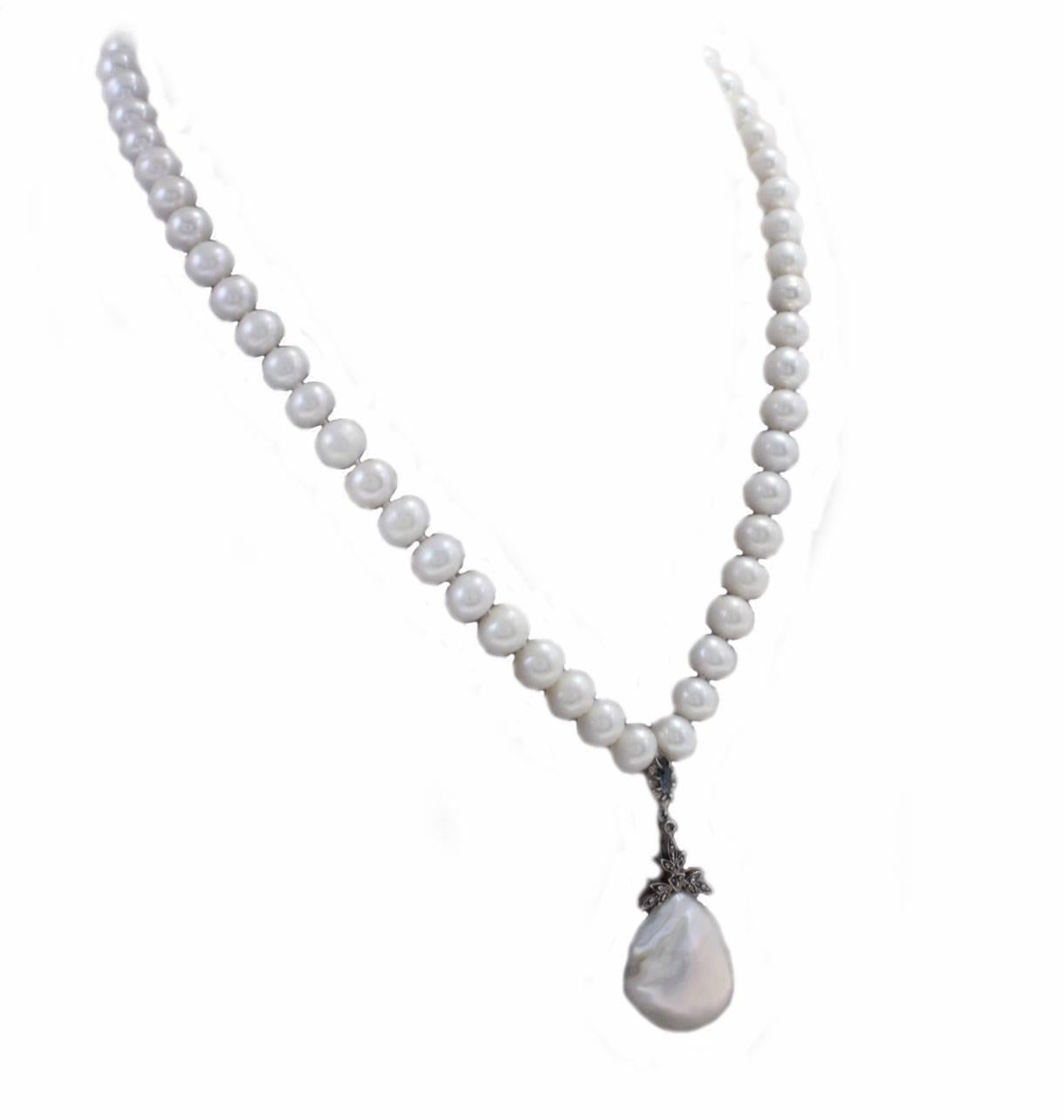 Beaded necklace in 9kt yellow gold and silver with a mother-of-pearl pendant embellished with diamonds and blue sapphires.

diamonds 0.08kt
pearls 7mm/0.27inch
tot weight 47.9gr
r.f. iea

