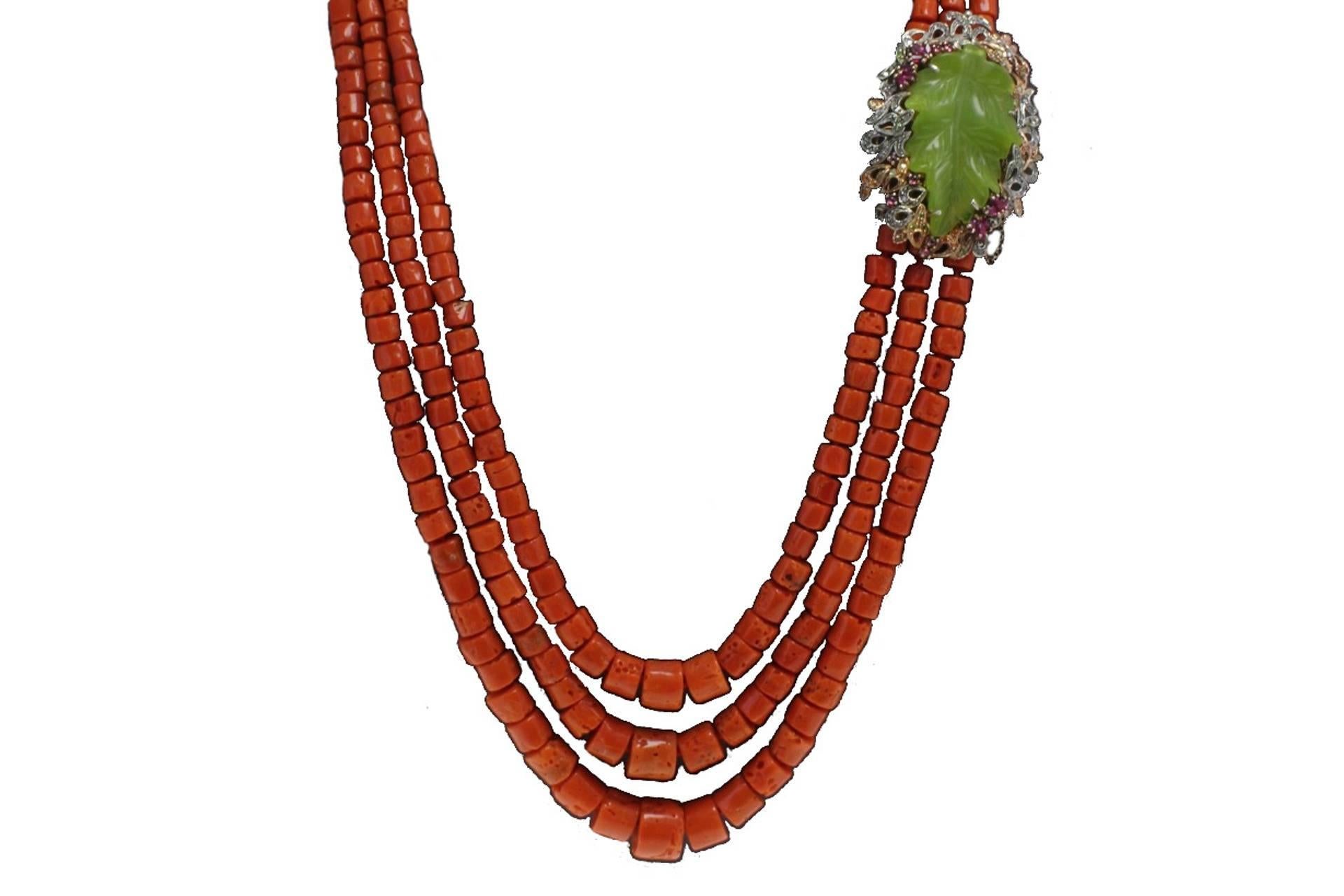 Coral multi-strand necklace with a leaf shaped clasp in 9kt yellow gold and silver surrounded by a crown of diamonds, rubies, coloured sapphires and amethyst.

diamonds 0.64kt
tot weight 195.2gr
r.f.  fgcg