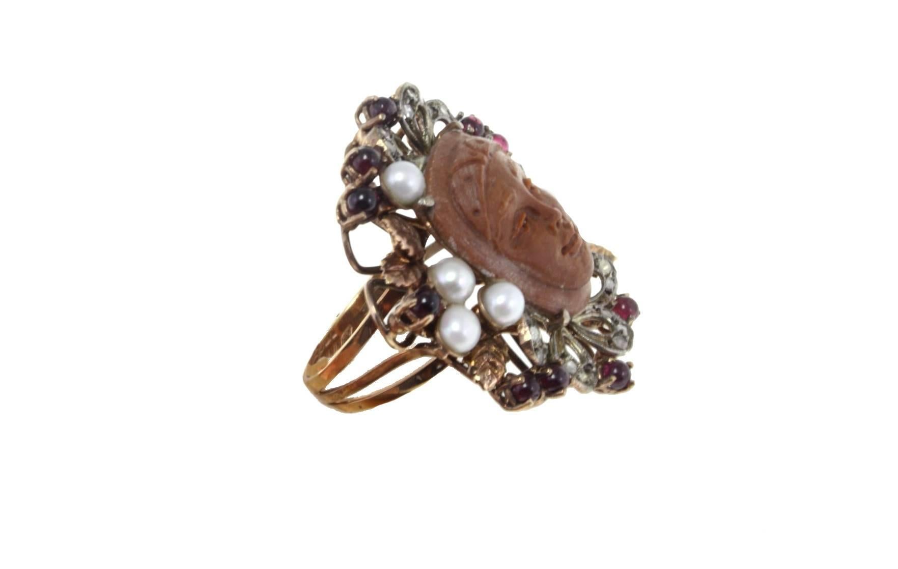 Lava stone cameo ring in 9ky rose gold and silver embellished with a crown of pearls, garnets and diamonds.

tot weight 11.5gr
r.f.  gauc