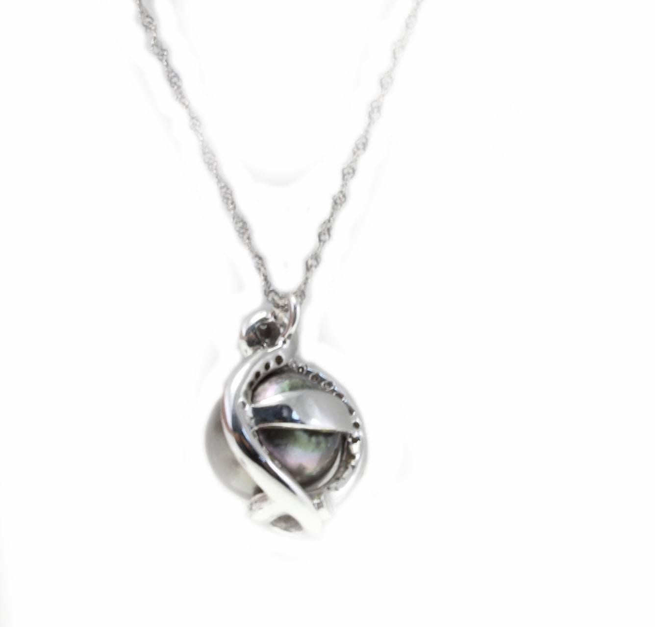 Charming and fashion necklace with a pendant composed of a single black pearl surrounded with a frame of diamonds.  All is mounted in 18Kt white gold. Chain run with the pendant.
Tot weight 8.3 gr
Diamonds 0.32 Kt
Pearl 11.06 ge, diameter 12mm

Rf.
