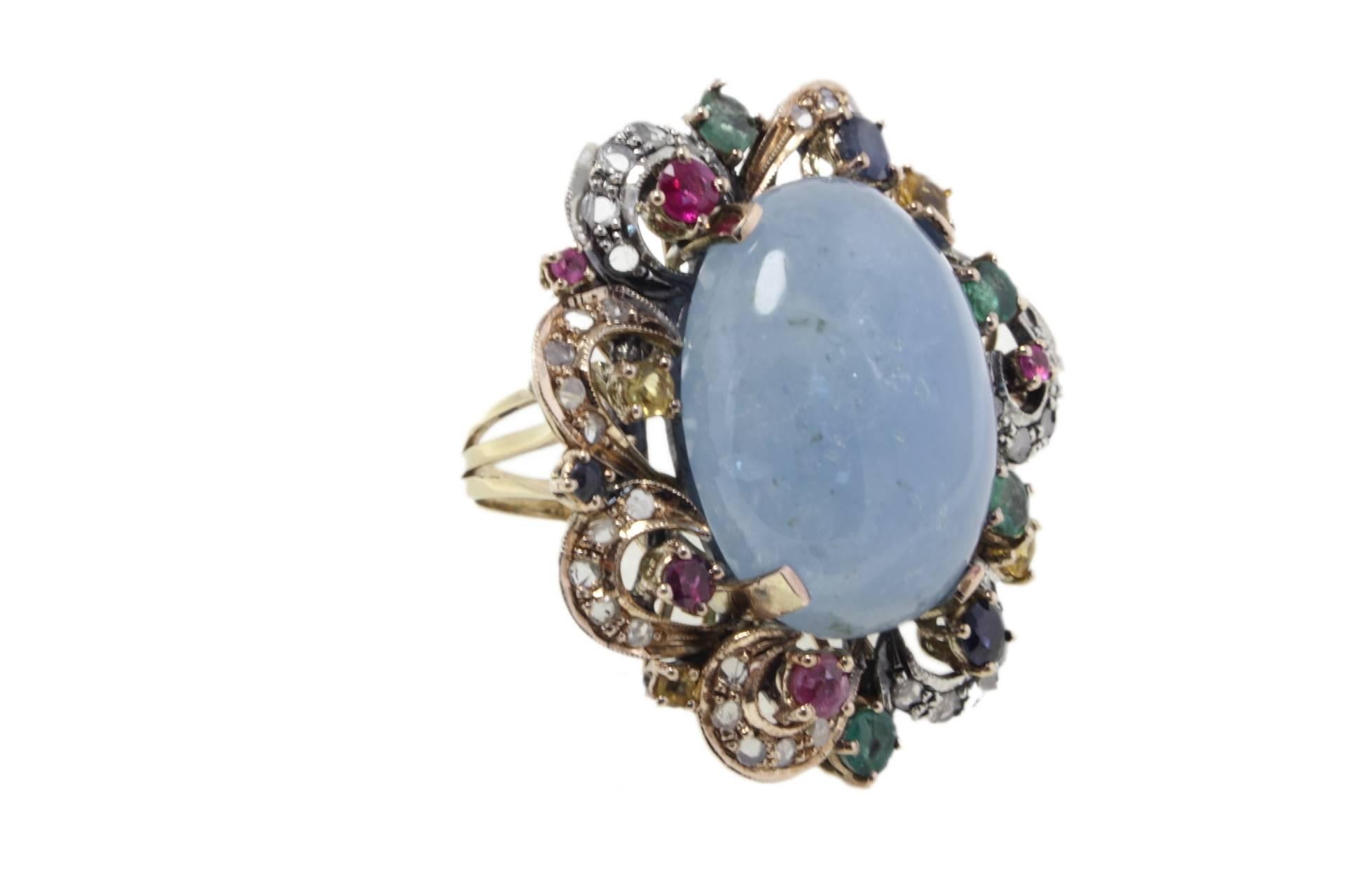 

Charming and shiny oval aquamarine surrounded ofemerald, diamonds, rubies and sapphires. All these sparkling gemstones are mounted on a 9 Kt rose gold and silver ring.
Ring Size: ITA 13.5 - French 53.50 - US 6.5 - UK N
Tot weight 14.5 gr
Diamonds