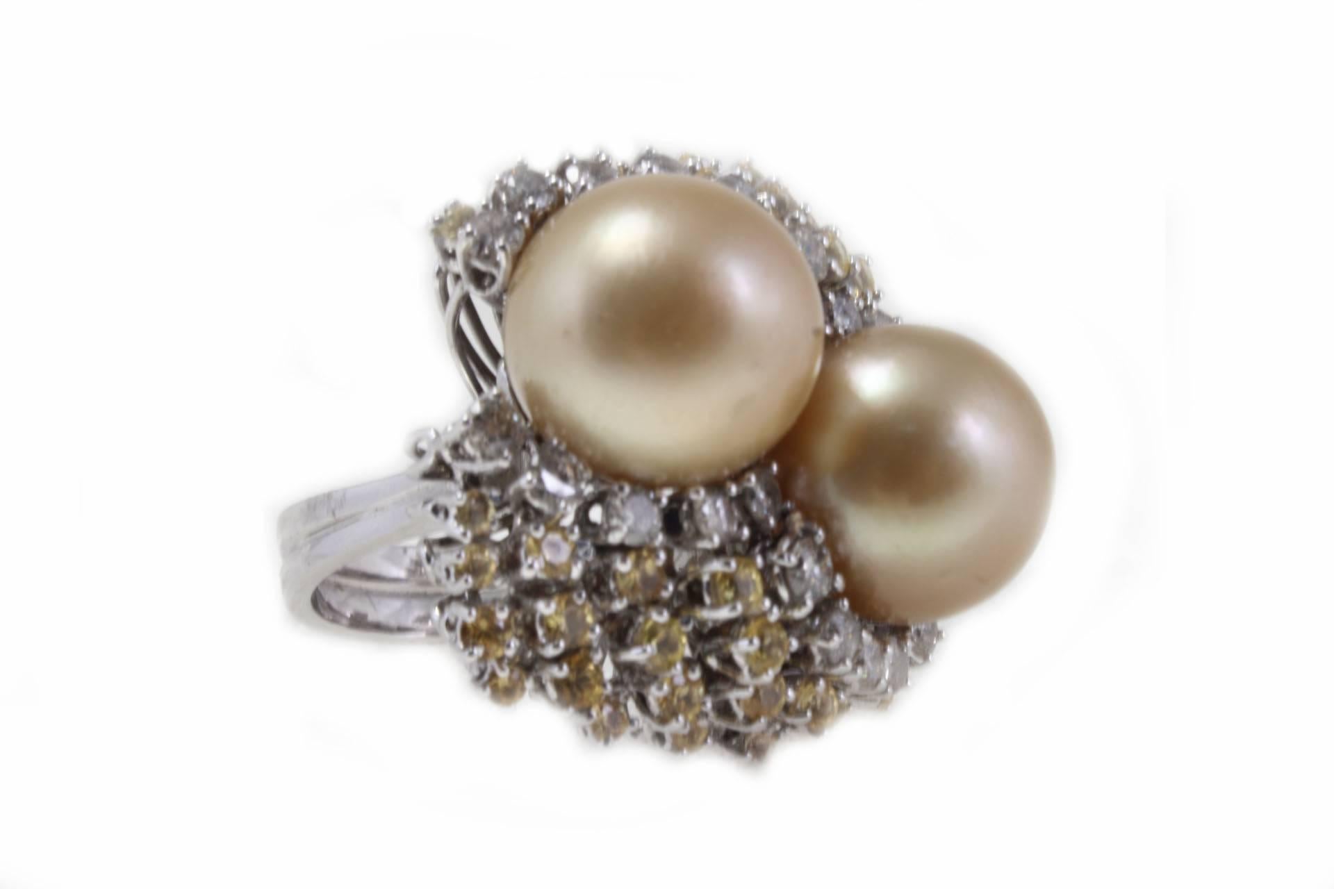 Sparkling cluster ring composed of 2 medium size Australian gold pearls, surrounded of diamonds and yellow sapphires. All is mounted in 18K white gold.
Ring Size ITA 16 - French 56 - US 7.5 - UK P
Tot weight 20.6 g
Diamonds 1.29 ct
Yellow sapphiers
