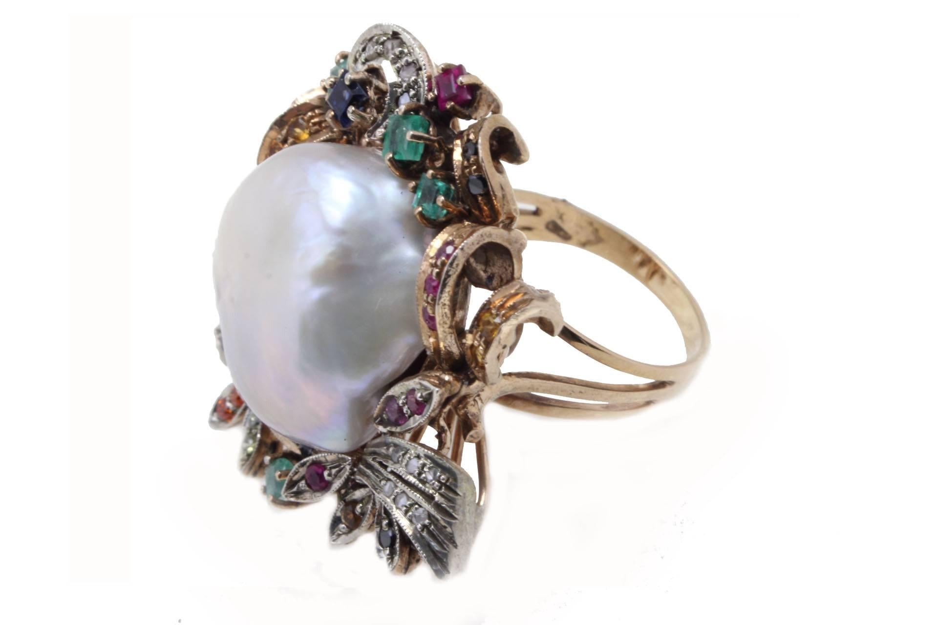 

Charming cocktail ring mounted in 9 K rose gold and silver, on it are encrusted diamonds alternating multi colored sapphires, emeralds and rubies as a frame for a pearl in the middle.
Ring Size: 16.5 - French 56.50 - US 7.5 - UK P
Tot weight 20.7