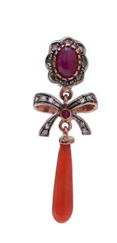 Orecchini con corallo, rubini, diamanti, oro rosa e argento.