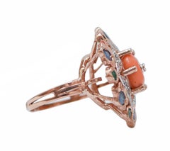 Anello con corallo, smeraldi, diamanti, zaffiri, oro rosa e argento.