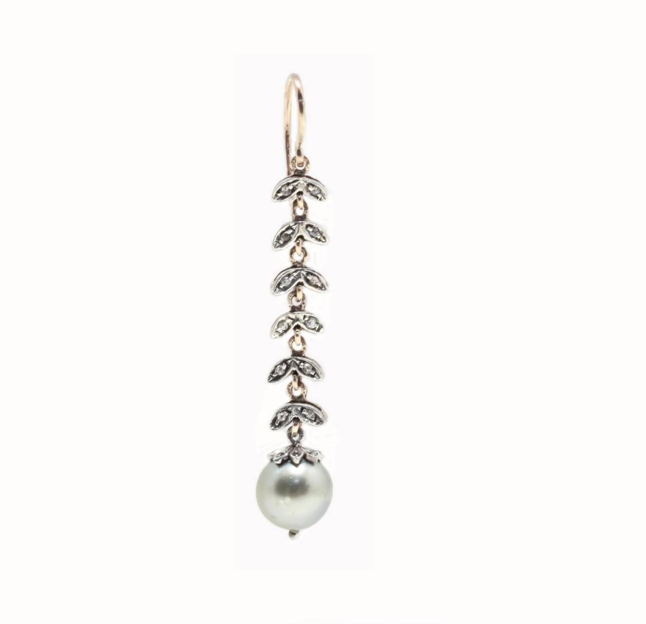 

Sparkling dangle  earrings composed of leaves's shape embellished with 0.44 ct of diamonds with a white pearl on a earring and a grey pearl on the other earring, at the bottom. All is mounted in 9K rose gold and silver structure.
 Diamonds 0.44