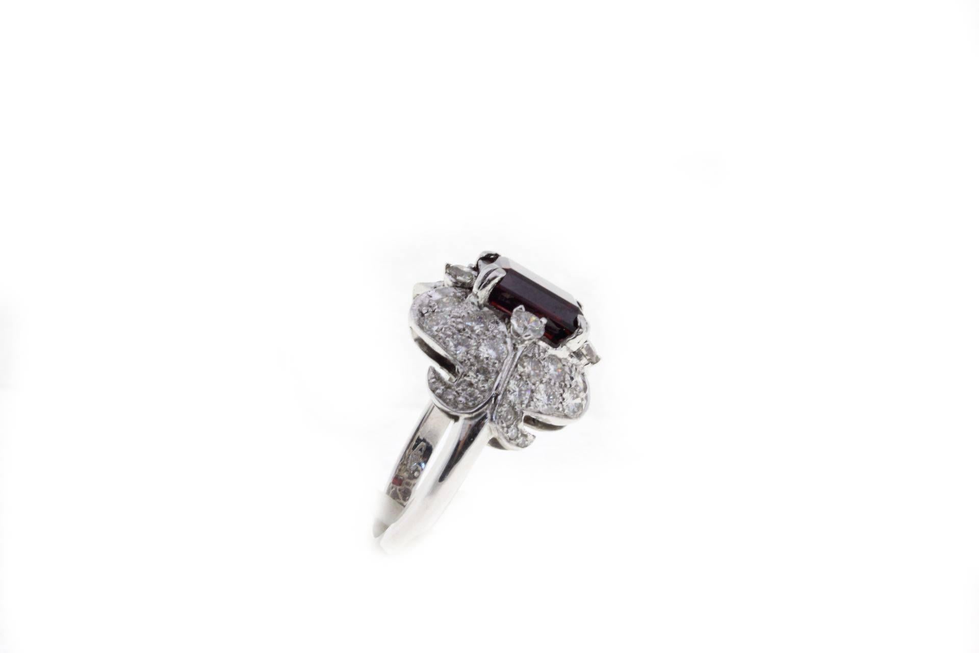 

Amazing and shining cluster ring composed of 2.06 ct of white diamonds that's surrounding a central garnet of 2.47 ct. All is mounted in 14K white gold. 
Ring Size ITA 13 - French 53 - US 6.5 - UK N
Diamonds 2.06 ct
Garnet 2.47 ct
Total Weight 7.5