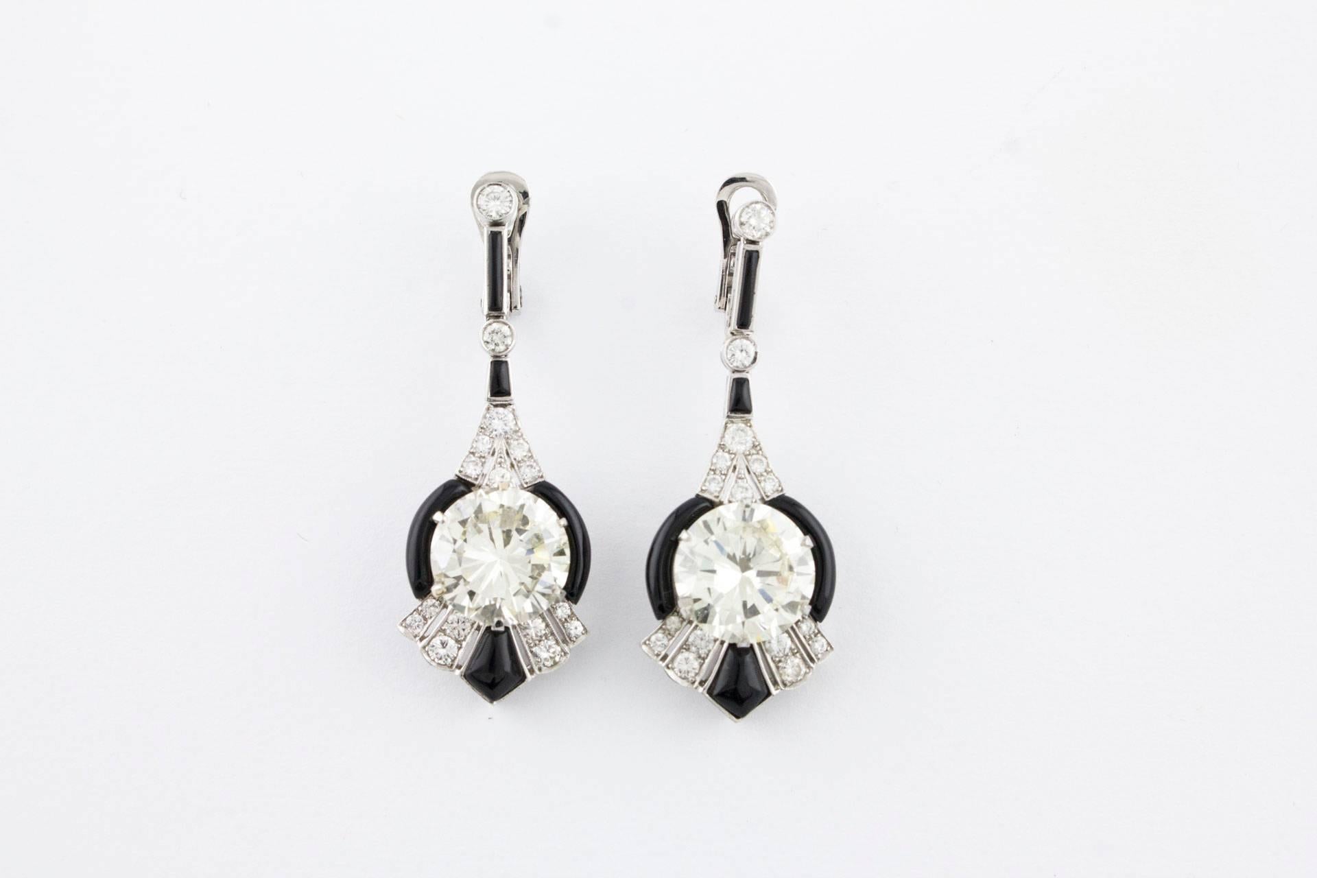 This prestigious dangle earrings are simply composed of a strands of onyx alternating with diamonds on top of them and to the bottom a onyx frame that's surrounding a central diamond. All is mounted in platinum.
The diamonds are coming with a