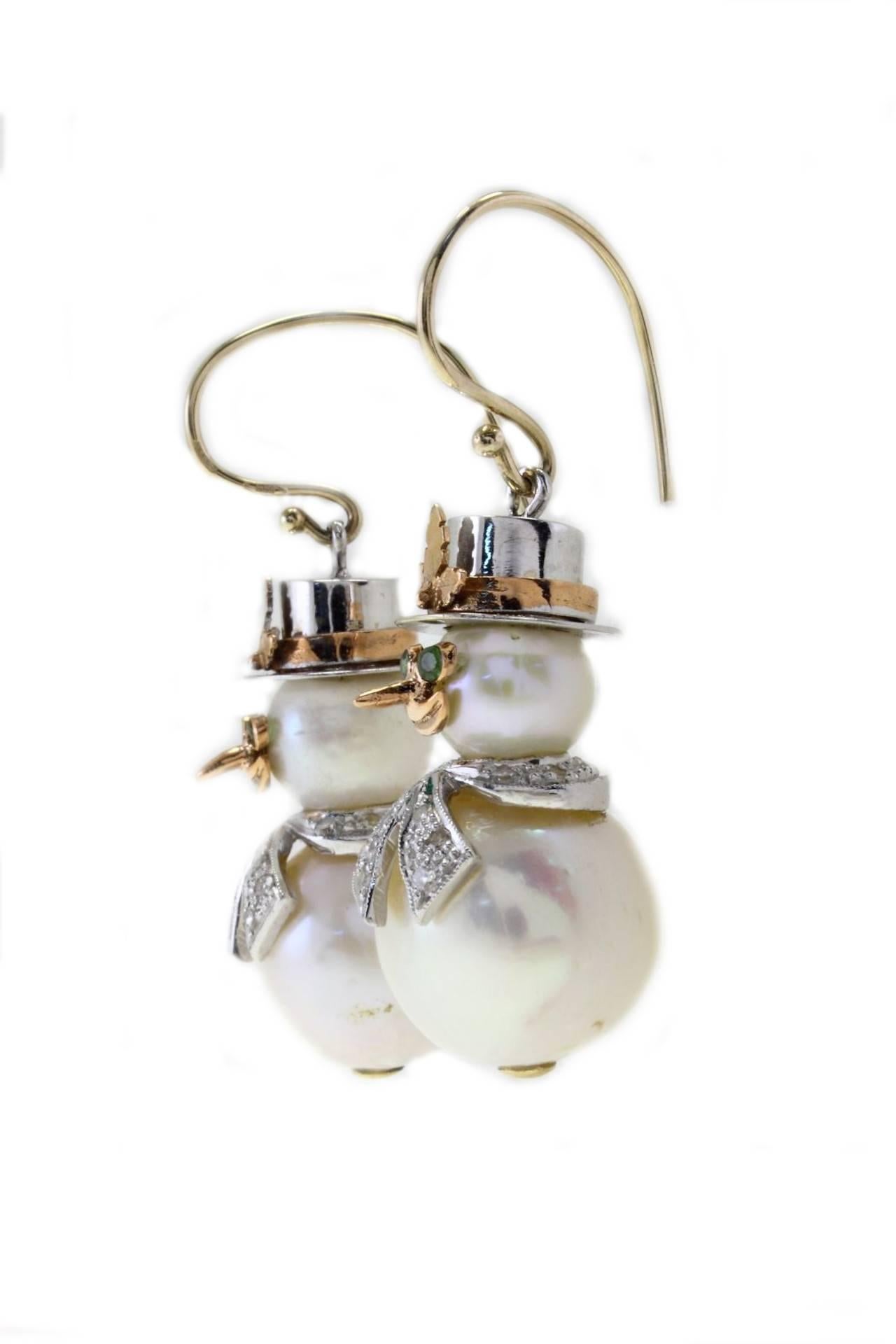 Snowman earrings in 14Kt gold composed of 2 big pearls, tsavorite as eyes and a diamond scarf.

diamonds (0.41 Kt). 
tsavorite (0.10Kt)
pearls(10.60gr)  diameter:  body about 16 mm and head 8.5 mm  
Tot weight 17.3 gr

Rf. geau
