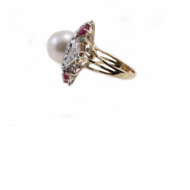 Anillo precioso de oro de 14 quilates  y  detalles en blanco  oro compuesto por una central  perla rodeada por una corona de diamantes, rubíes y esmeraldas.
Talla del anillo: US 7.5 - ITA 16 - Francés 56 - UK P
Peso total 13.6 gr
Diamantes 0,39