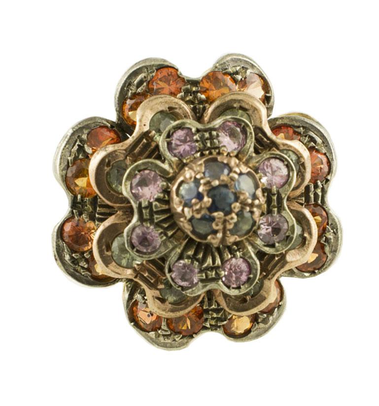 Fabulous flower shape cluster ring in 9K rose gold and silver structure, all studded by deep multi-colored sapphires (Blue, Pink, Green, Yellow).
Multi-colored Sapphires 4.59 ct 
Total weight 11.60 g 
R.F + cuf
Diameter 24 mm  
Italian size