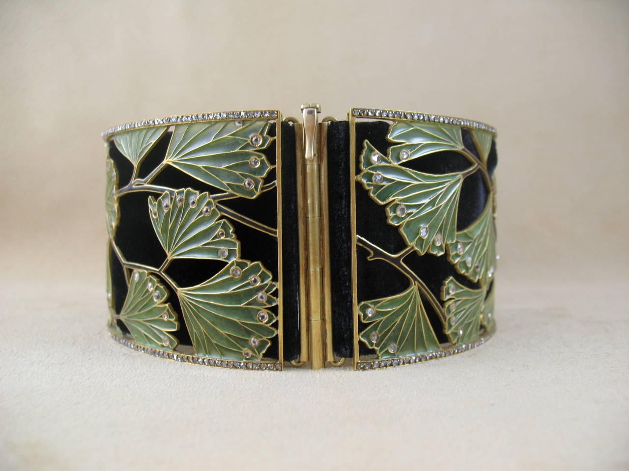 Designed as three openwork panels of green plique-à-jour enamel ginkgo leaves, enhanced by black enamel stems and rose-cut diamonds, trim of rose and old European-cut diamond, backed by a black velvet ribbon, mounted in 18k yellow gold, French,