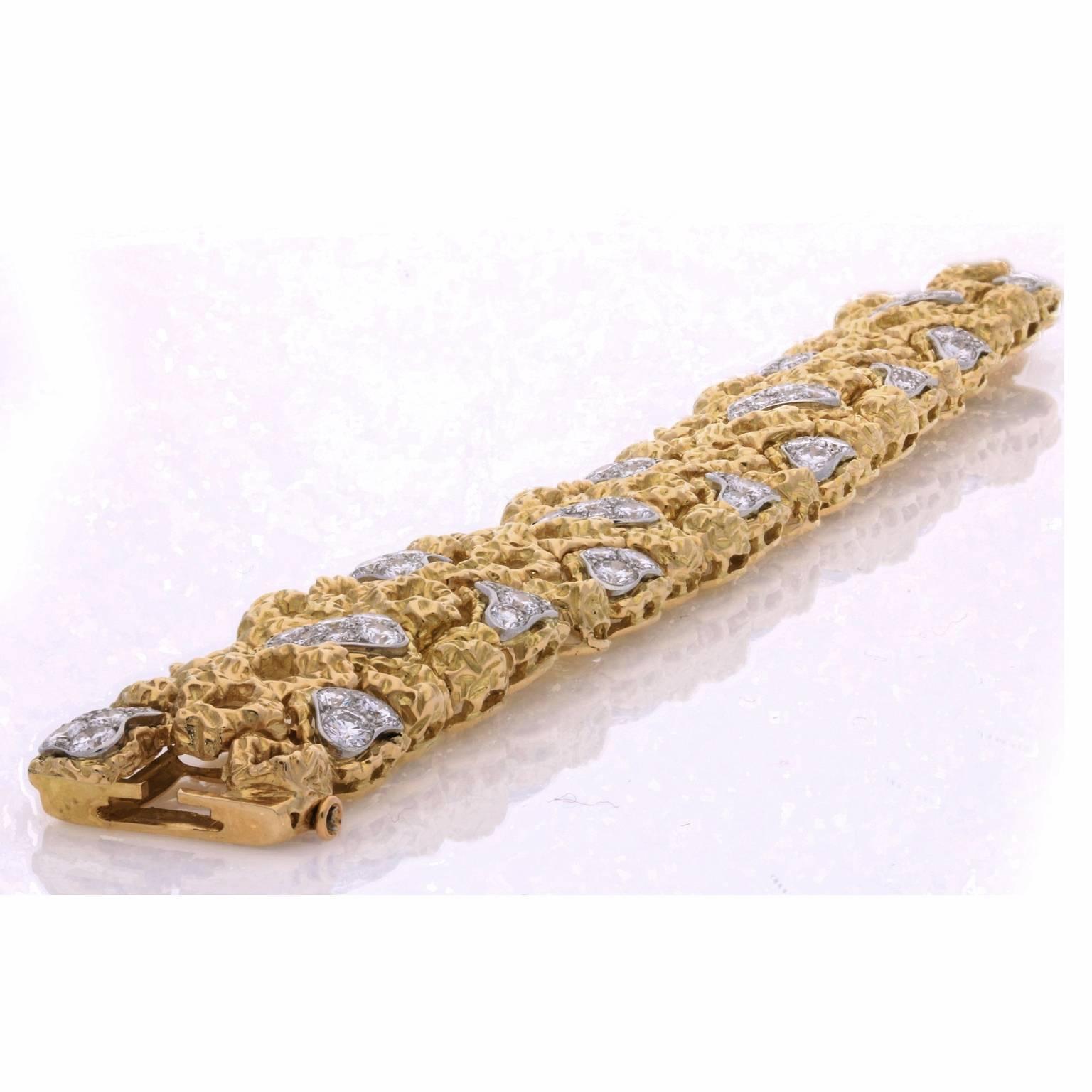 The stylish bracelet in heavily textured 18ct gold and of openwork, articulated panel design composed of a repeating pattern of irregular off-round motifs some of which are pavé set with round brilliant cut diamonds to a concealed tongue and box