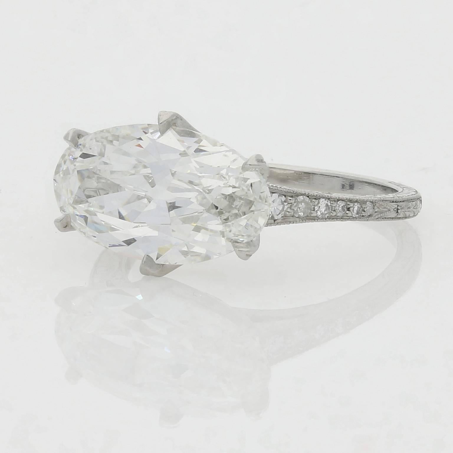 Der wunderschön geschliffene Diamant ist mit sechs Krallen quer über den Finger in einen fein diamantbesetzten und gravierten Platinring gefasst. 

Hancocks:: London

Altschliff-Diamant:: zeitgenössische Fassung

4::07ct H SI1