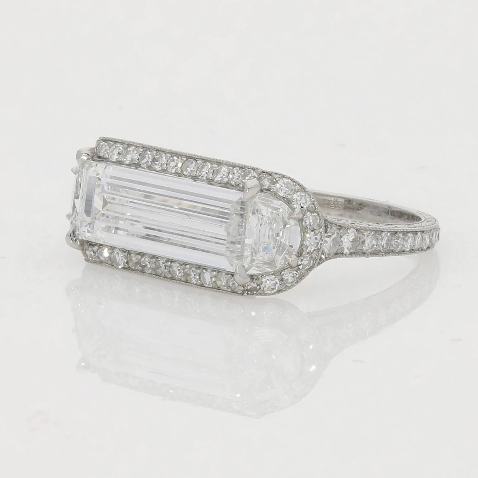  Unique ring set horizontally with a baguette-cut diamond between two demi-moon cut diamonds with a pavé diamond surround and shoulders in a finely engraved shank.

Hancocks

Contemporary

London

1.78ct D VS1 baguette-cut diamond