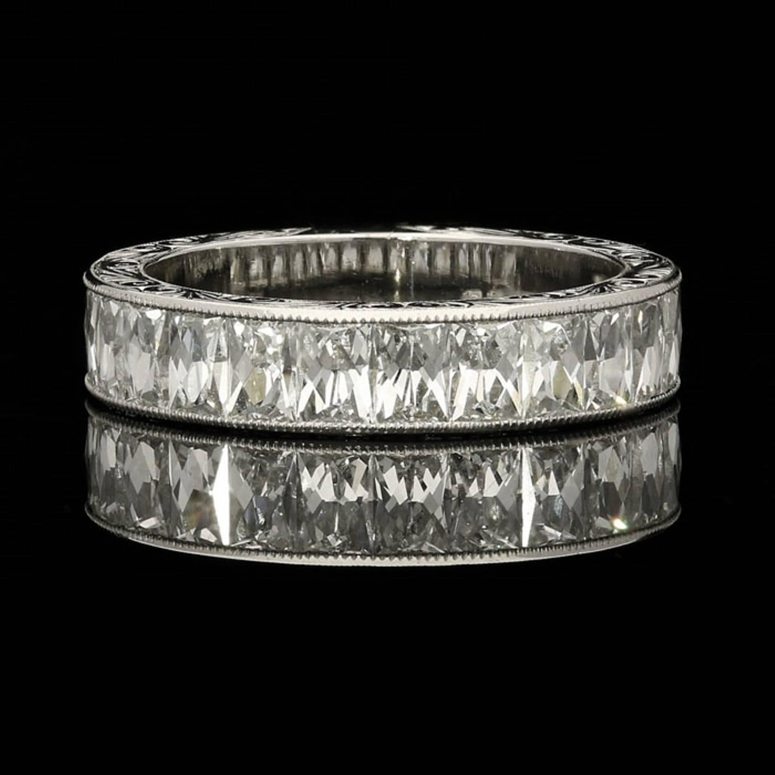 Der Ring ist zu 3/4 mit rechteckigen Diamanten im französischen Schliff besetzt:: die in dekorativ handgraviertem Platin eingefasst sind. 

15x rechteckige Diamanten im französischen Schliff von Farbe G und Reinheit VS mit einem Gesamtgewicht von