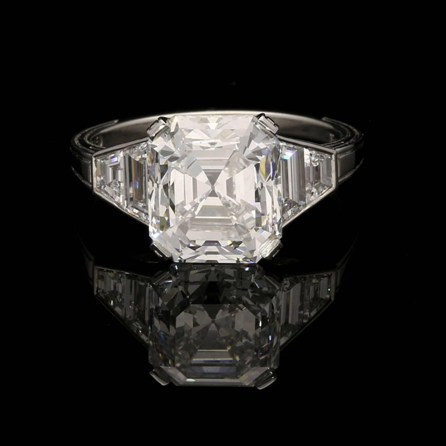 The ring centred on a beautiful antique emerald-cut diamond weighing 4.21cts and of D colour and VS2 clarity claw set in a fine handmade platinum mount, the shoulders rub over set with graduated trapezoid diamonds tapering to a plain shank with