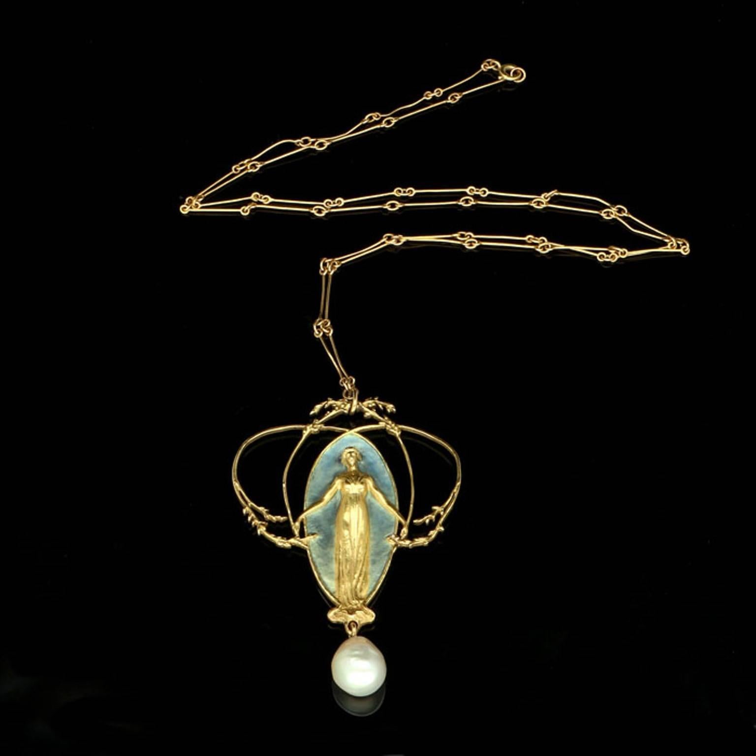 The pendant designed as a female figure in classical dress with her hair worn up and her arms outstretched, modelled in unadorned yellow gold against a background of blue enamel which fades gradually towards her feet, framed by arching foliate