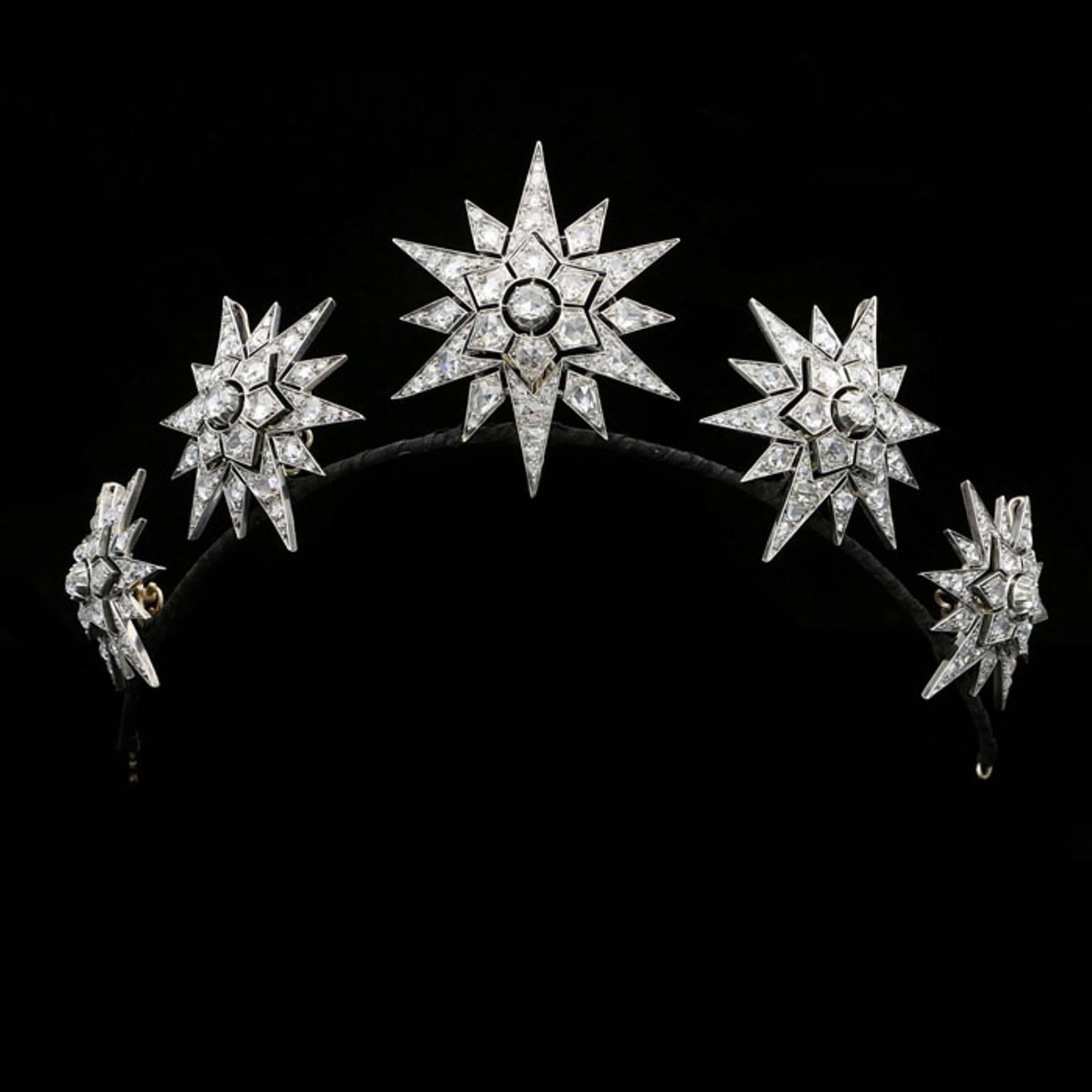 The tiara composed of five twelve-rayed stars graduated in size, all of openwork design and set throughout with rose-cut diamonds, all detachable and with pendant loops and separate brooch fittings for ease and flexibility of wear making this a
