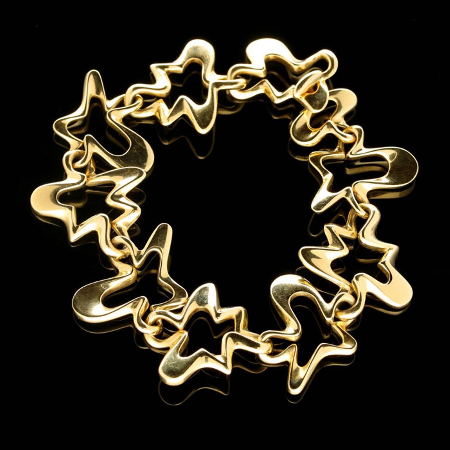 The bracelet in 18ct yellow gold designed as a series of open asymmetric ‘splash’ motifs with irregular outlines of varying thickness all interlinked and with a toggle style clasp. This wonderfully sculptural and tactile piece was originally
