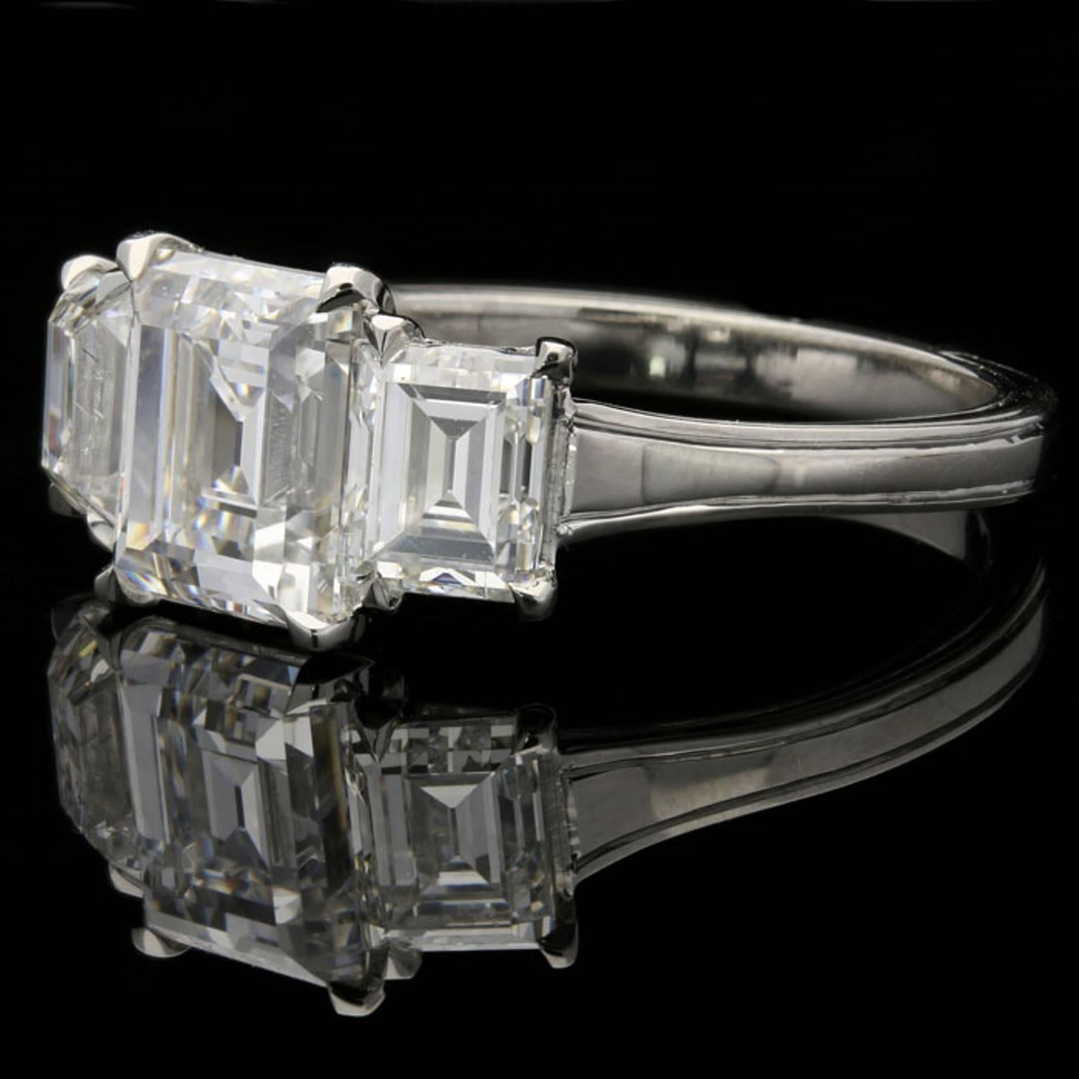 The ring set with three beautifully cut and matched old rectangular step-cut diamonds, the centre stone is 2.13cts and F colour VS1 clarity and is flanked by a 0.76ct F colour VVS2 clarity and a 0.74ct E colour VS2 clarity, all three are corner set