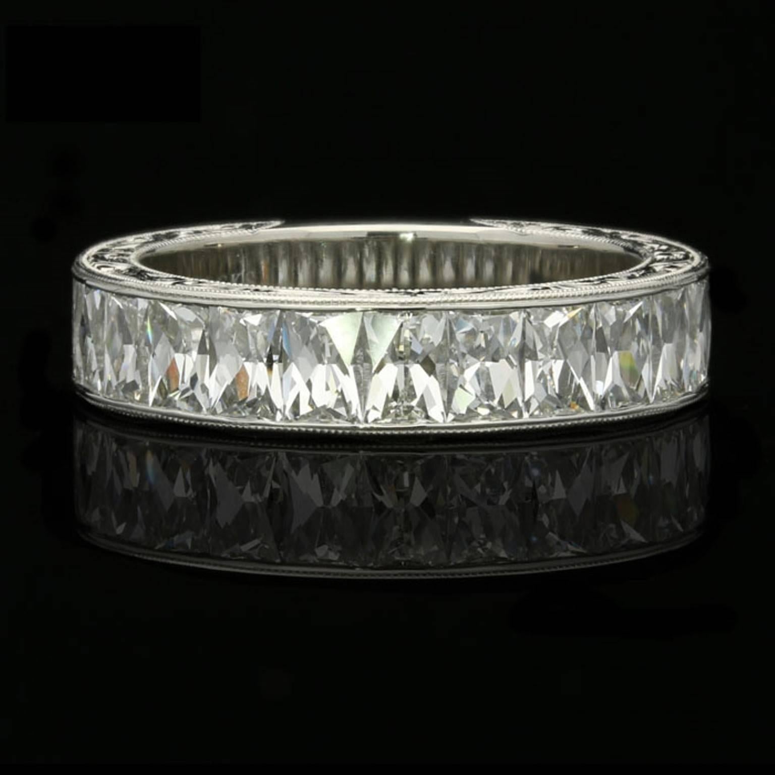 The ring three quarter set with beautiful rectangular French cut diamonds weighing a total of 2.75cts set vertically within a finely crafted and ornately hand engraved channel set platinum mount.

15 rectangular French cut diamonds with a combined