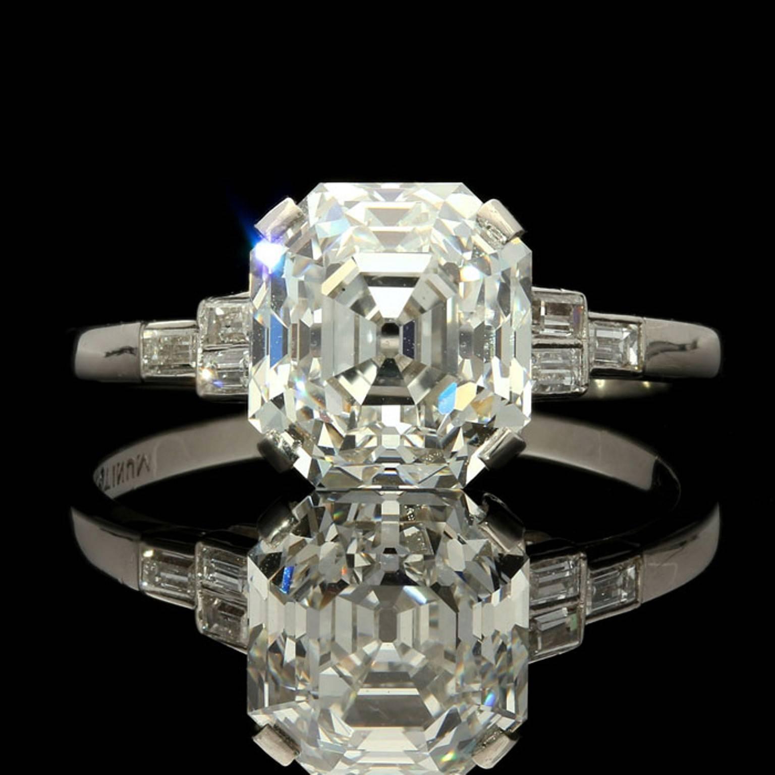 The ring centred on a beautiful early Asscher cut diamond weighing 4.09cts and of G colour and VS1 clarity corner claw set in an elegant, open, simple gallery with three baguette diamonds to each shoulder and a fine shank, all in platinum.

4.09ct
