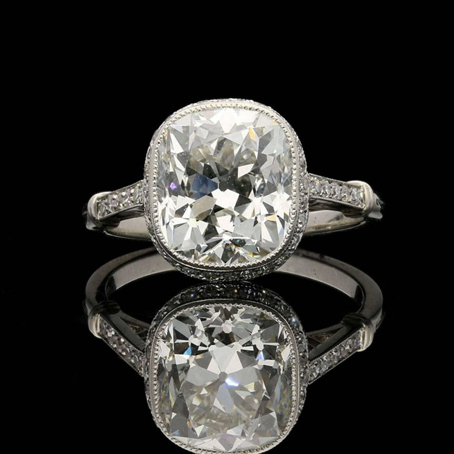 A stunning old-cut diamond solitaire ring by Hancocks centred with a beautiful rectangular old mine brilliant cut diamond weighing 4.14 carats in a millegrain rubover setting to a finely pierced cupped gallery set throughout with rows of single cut