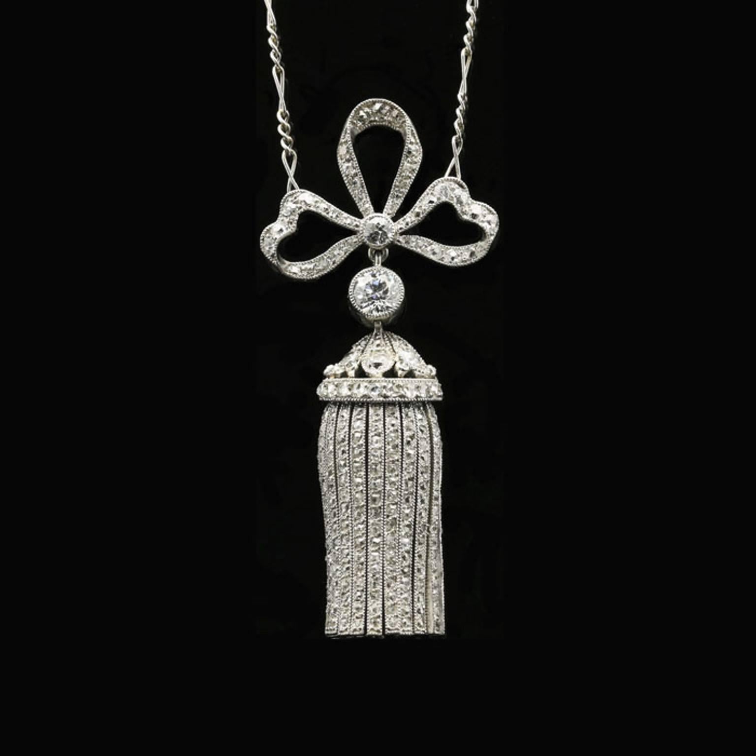 A Belle Époque diamond bow and tassel pendant c.1905, the elegant and beautifully romantic pendant set from a  realistically designed diamond set ribbon bow suspending a rose-cut diamond set flexible tassel, all to a platinum chain.


Old European