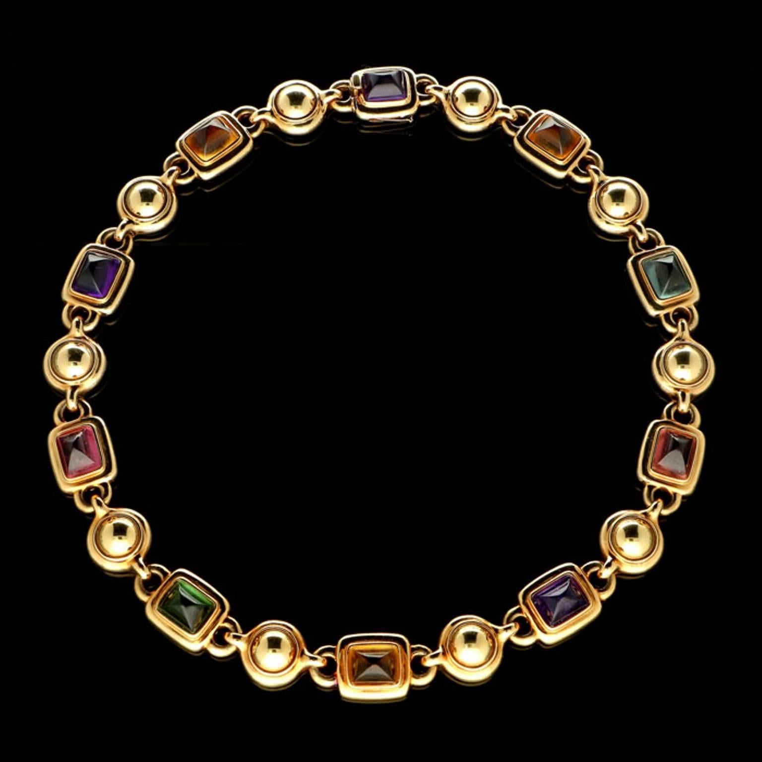 A bold and stylish multi-gem necklace by Chanel, c.1980s, the necklace designed as a continuous row of rectangular sugar loaf cabochons of amethyst, citrine, topaz, and tourmaline all rub over set within wide rounded 18ct yellow gold open backed