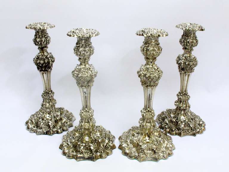 Set of four Sheffield sterling silver candlesticks made by S.C. Younge & Co.  dating 1821. Each one engraved with a family crest,a single spider and web, in a well on the base.

Weighted candlesticks, approximate gross weight 185oz,